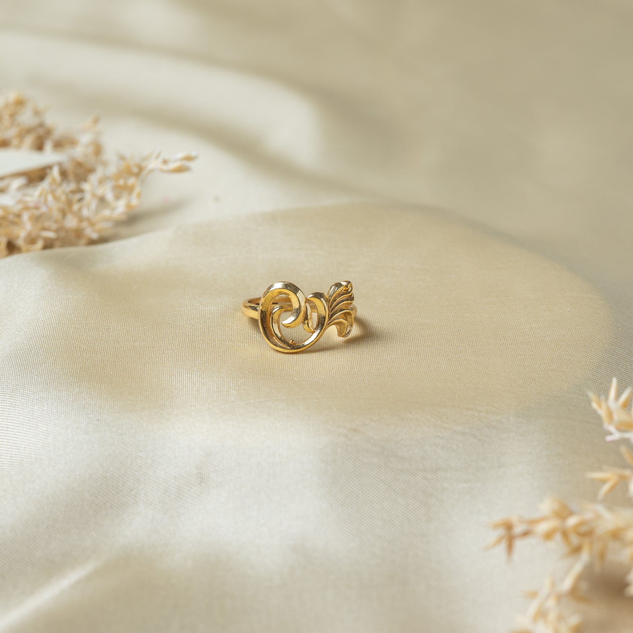Gold jaali ring with a large C spiral and a fan of four leaf blades over the band