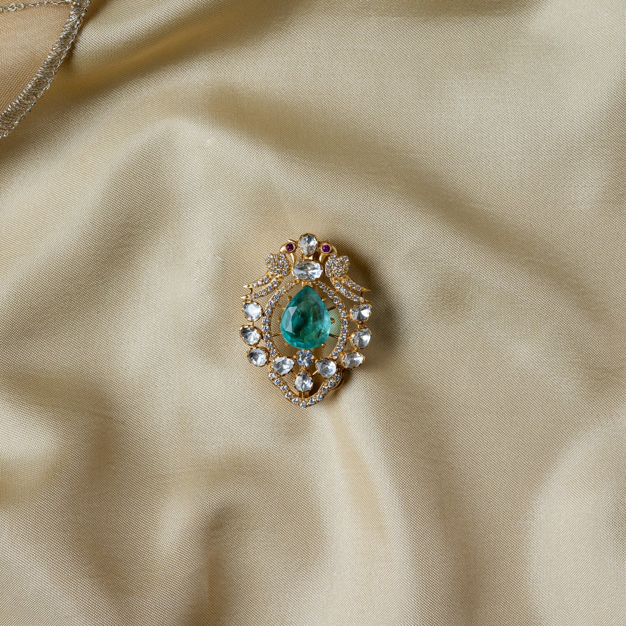 Polki lotus bud brooch with a pear cut green centre in a ring of nine uncut polki, gold plated 925 silver