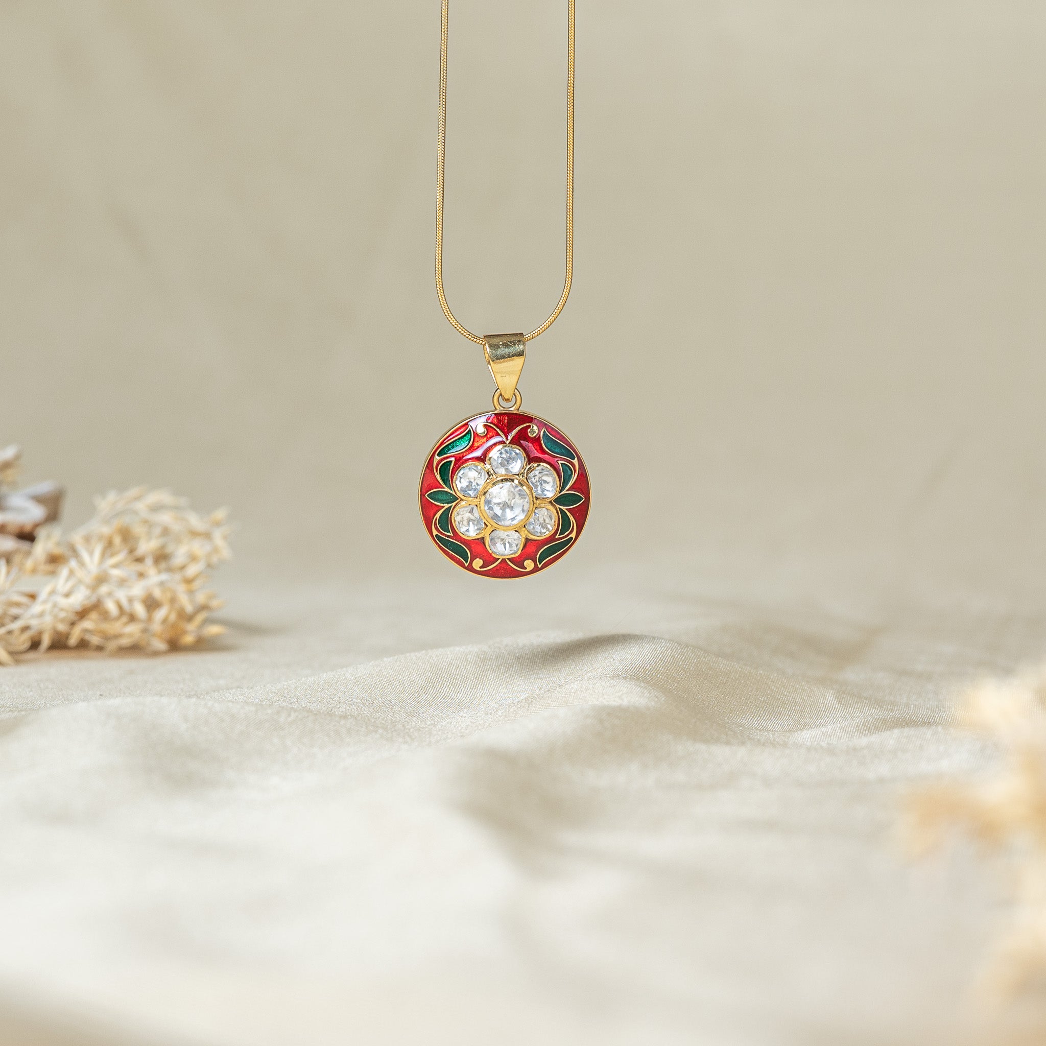 Red meenakari flower pendant, seven uncut kundan stones and green enamel leaves, shown on a snake chain