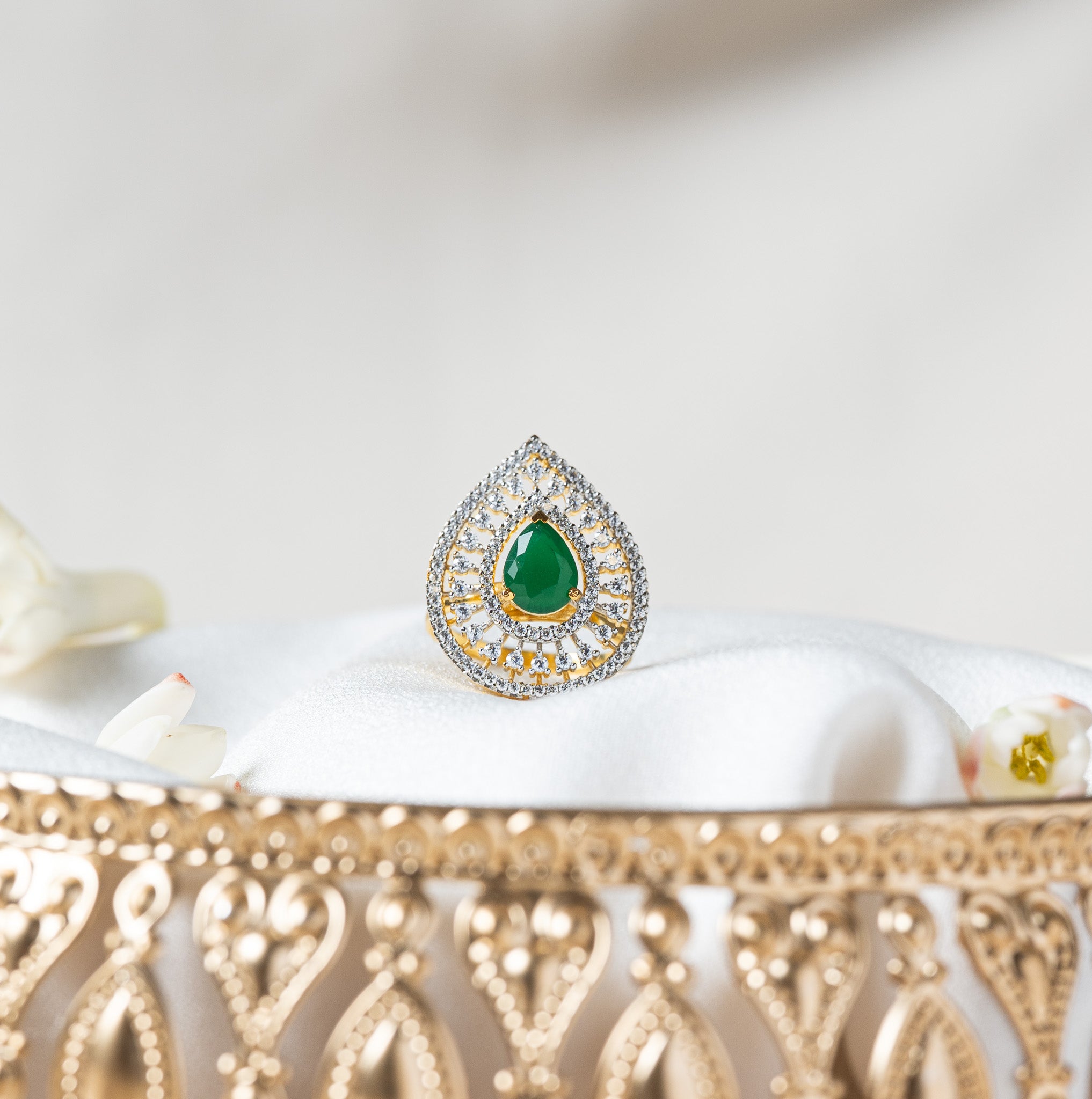 Teardrop cocktail ring with a green pear cut stone in a CZ pave halo on gold plated 925 silver