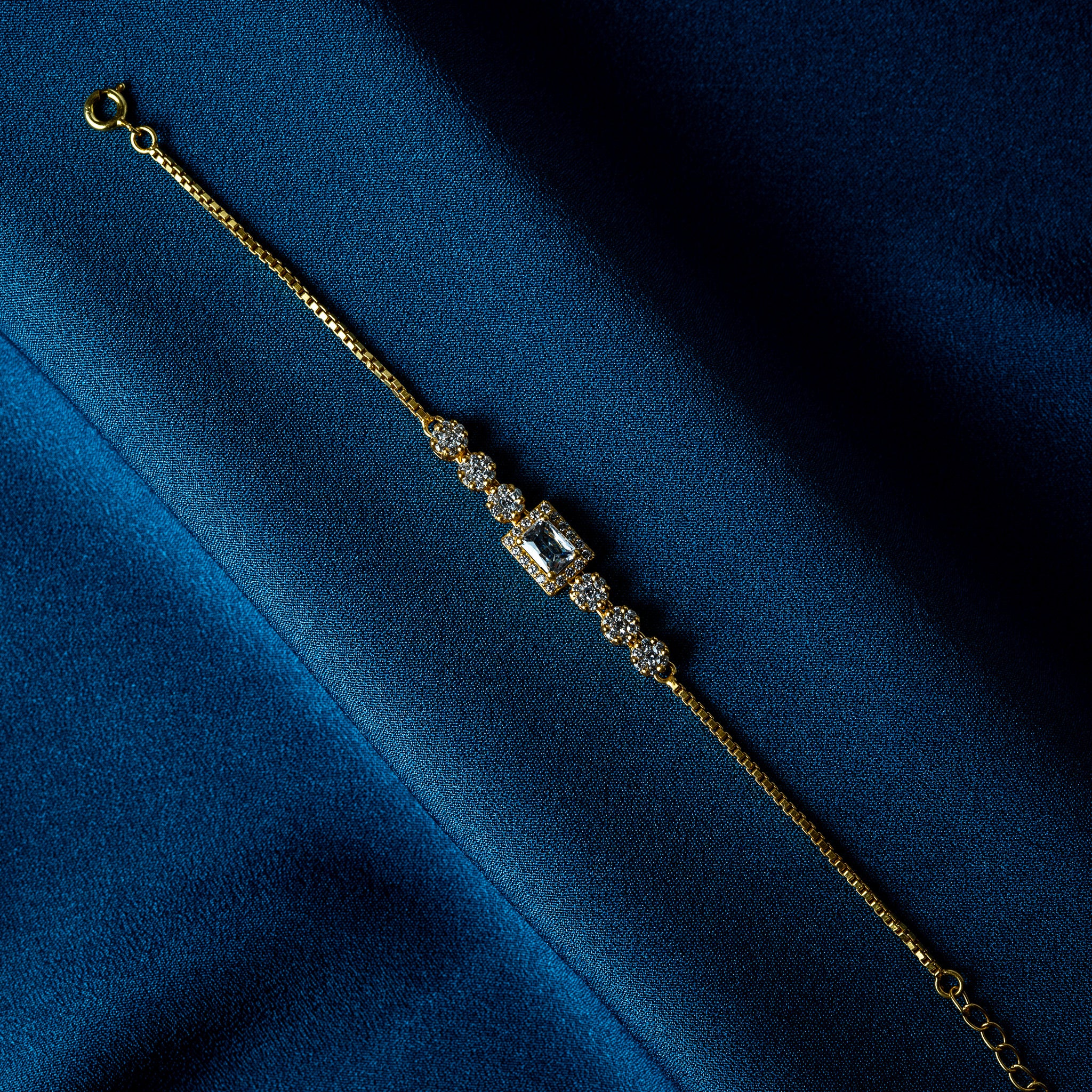 Close crop of the rectangular step cut CZ in its pave frame on a gold plated bracelet