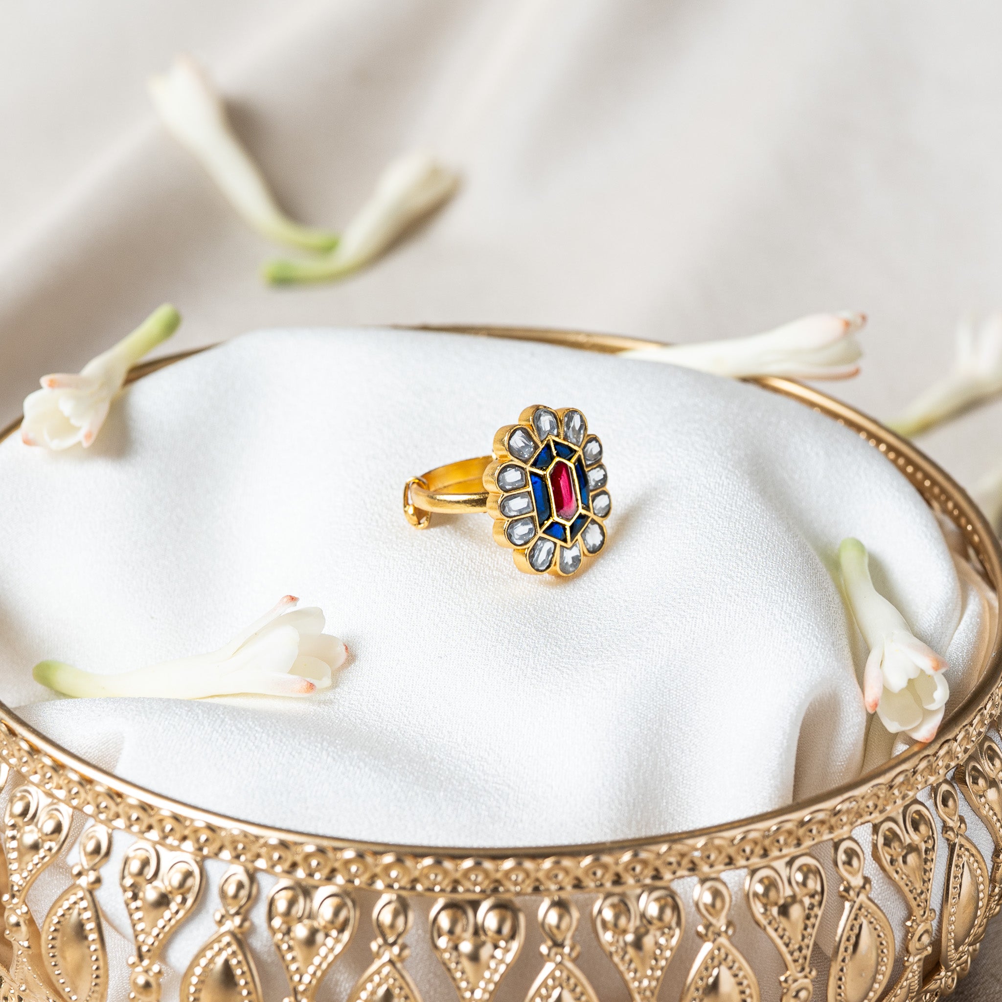 Front view of the kundan flower ring showing six flat cut blue kundan around the centre stone