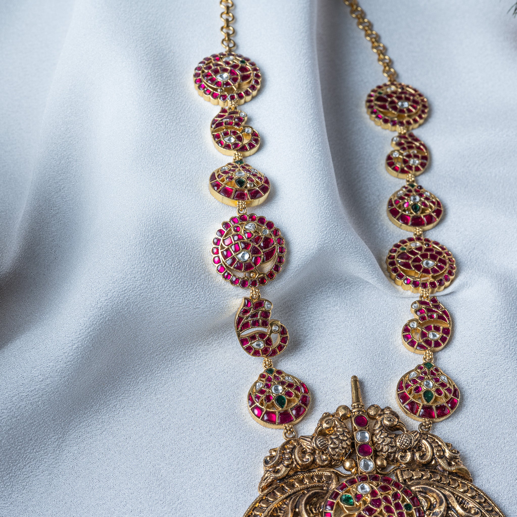 Red, white and green kundan discs alternating with mango motifs along the chain