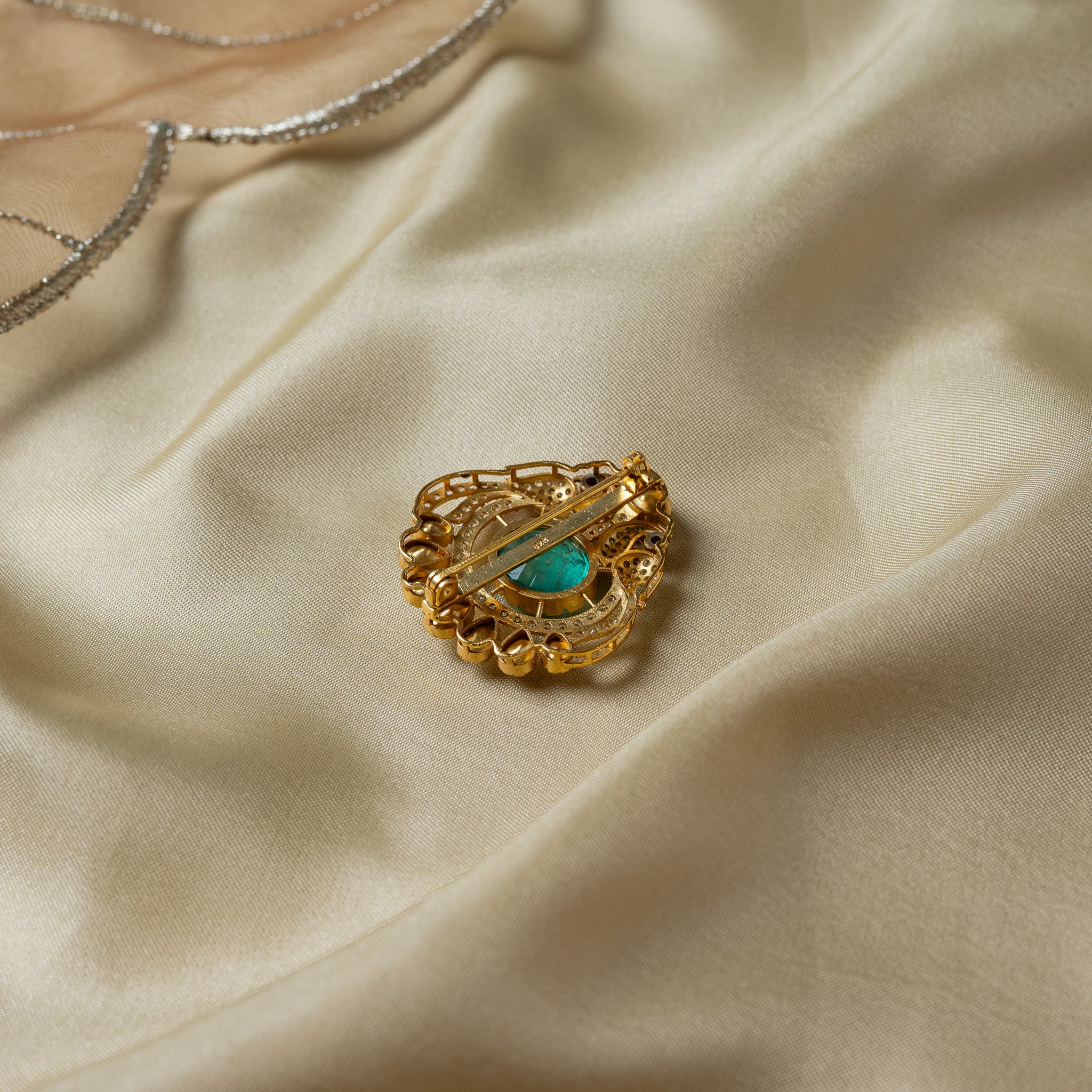 Back of the paisley brooch showing the flat mounting bar, rolled hinge and hook catch of the brooch pin