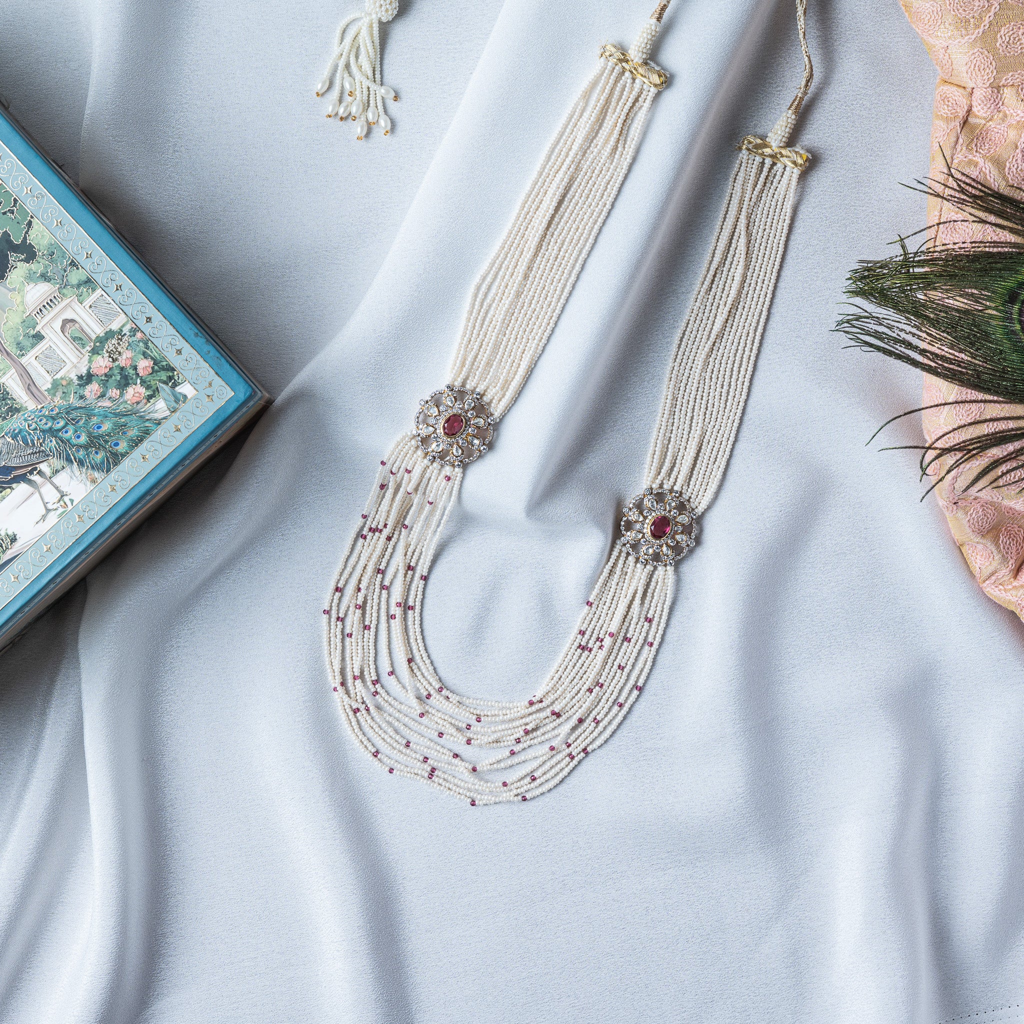 Ten strand rice pearl necklace laid flat with its braided ivory cord and thread tassel