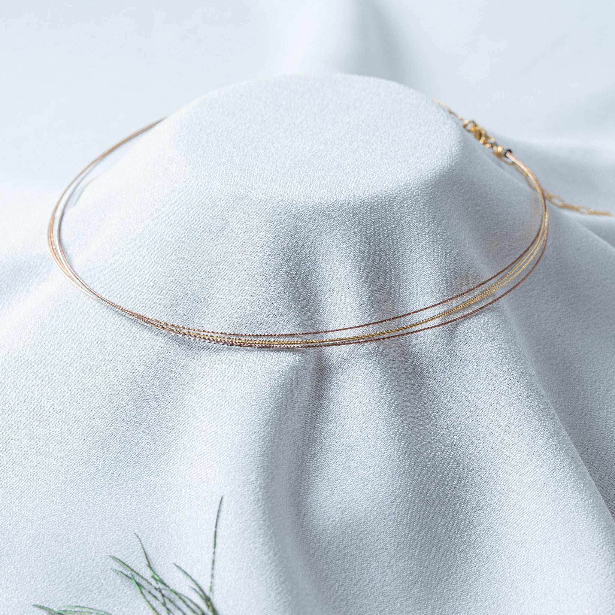 Close crop of the gold clasp and end cap area of the tri tone wire collar