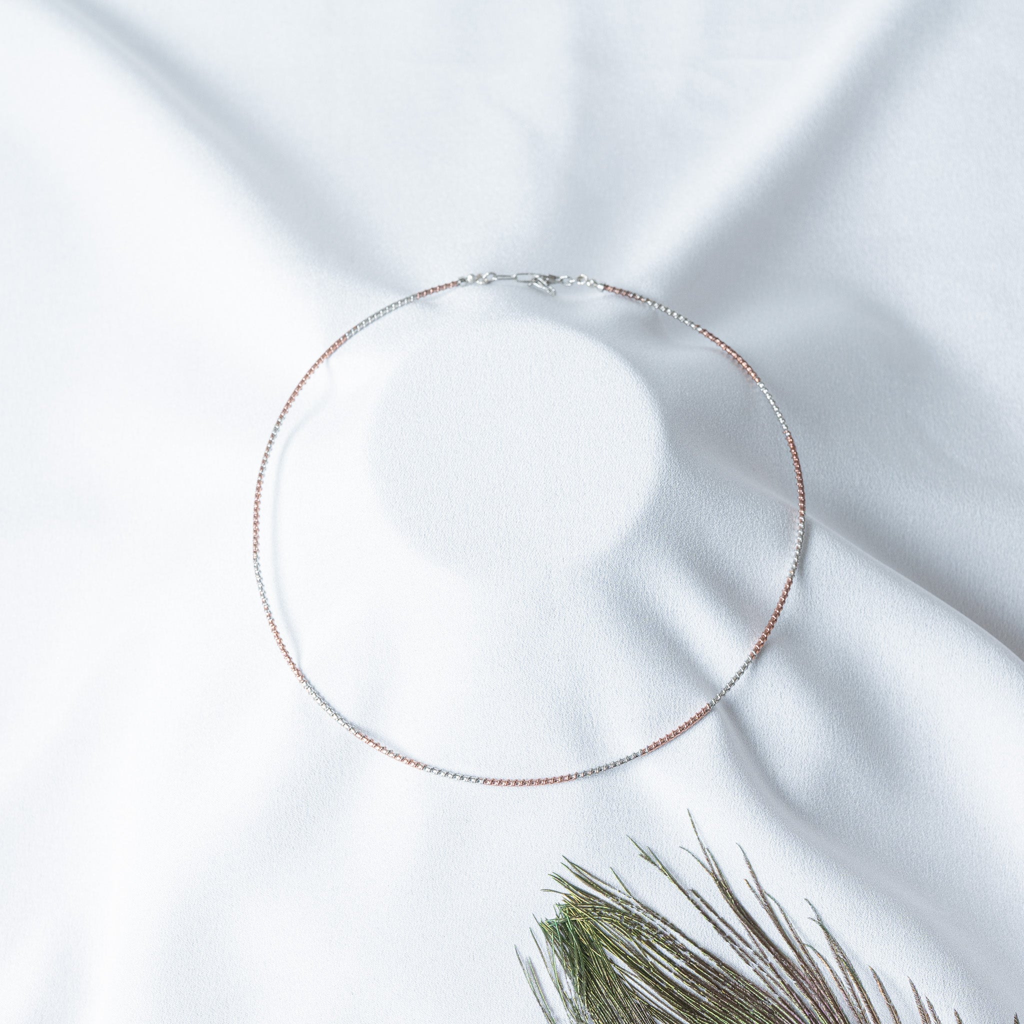 Close crop of the fine flat box link alternating rose gold and white on a 925 silver collar