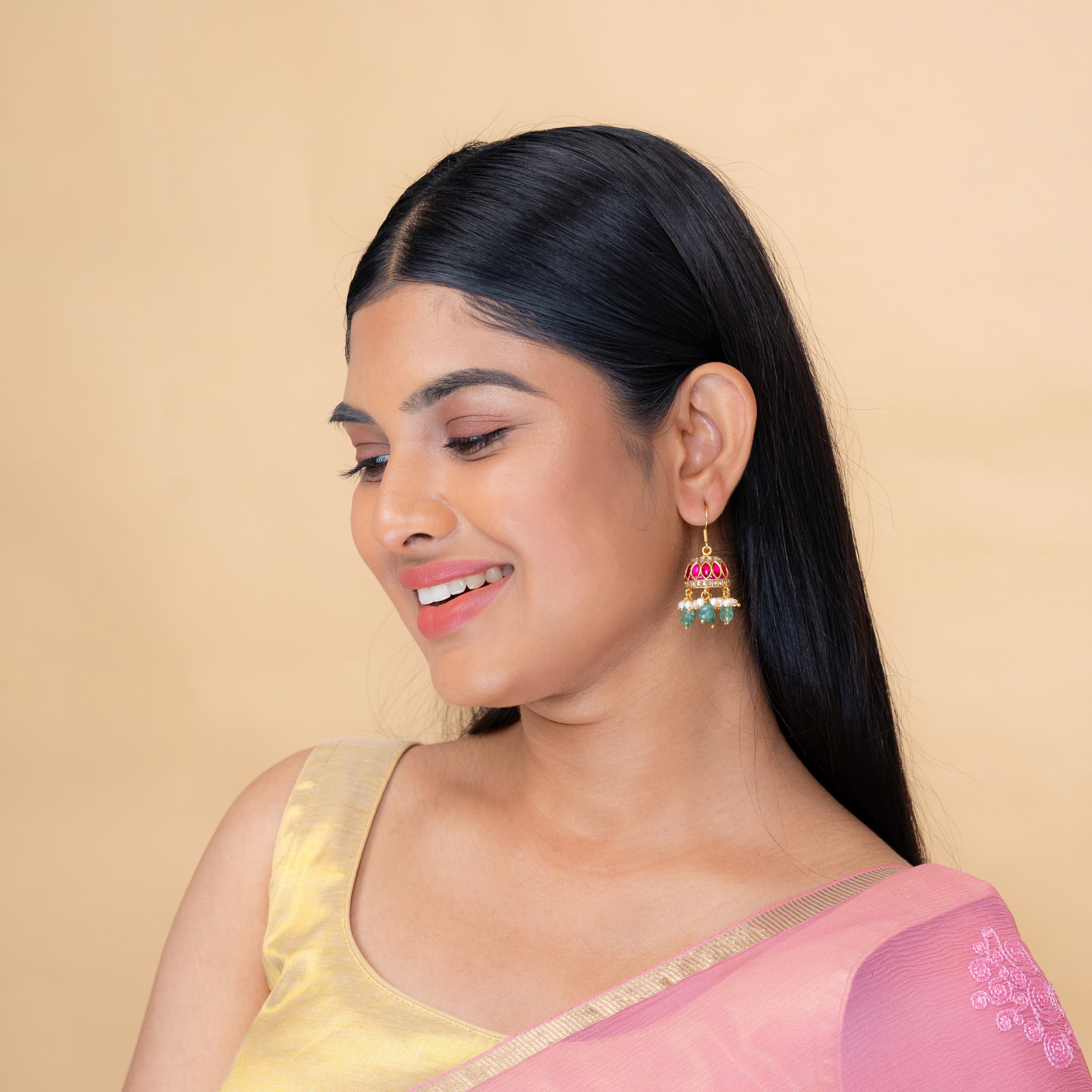 Model wearing Elira kundan jhumka earrings with pearl and aventurine detailing by Aurika