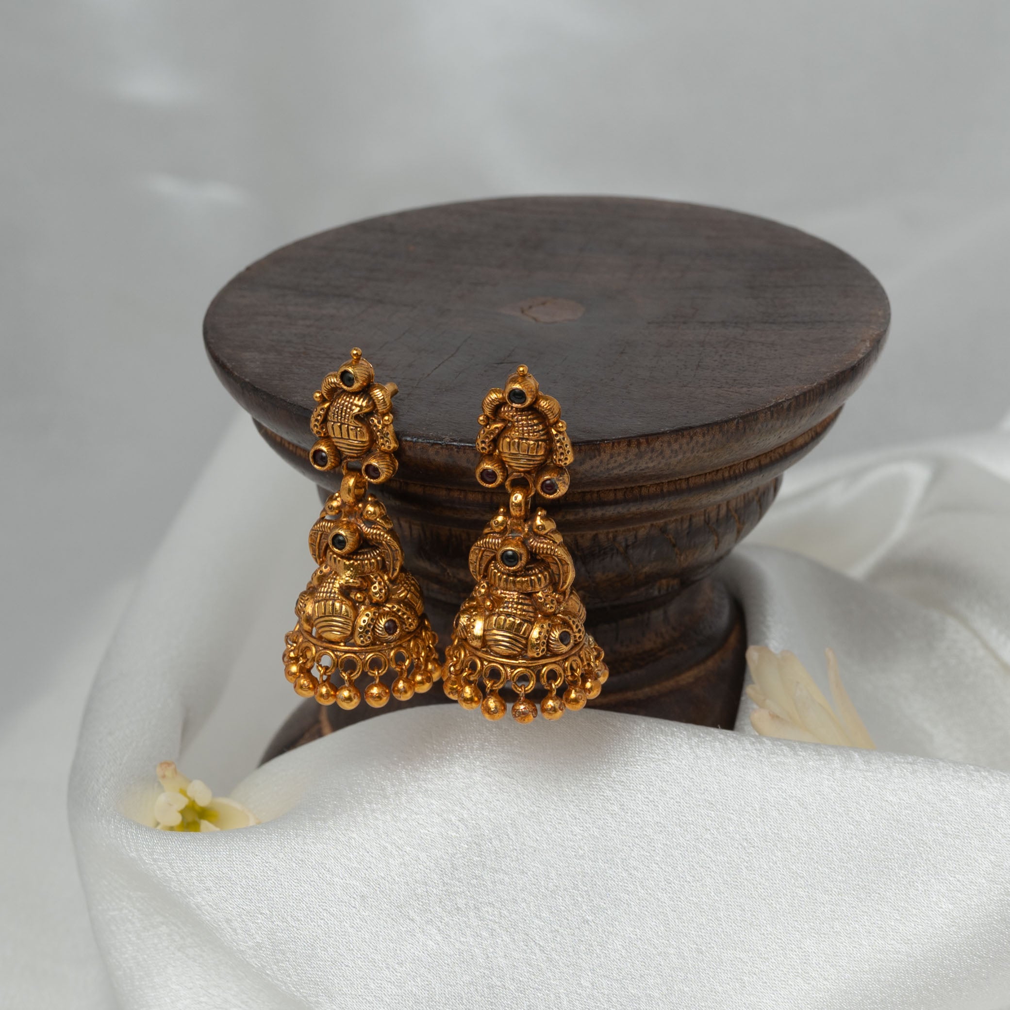 Close view of the ornate stud top and dark cabochons above the temple jhumka dome