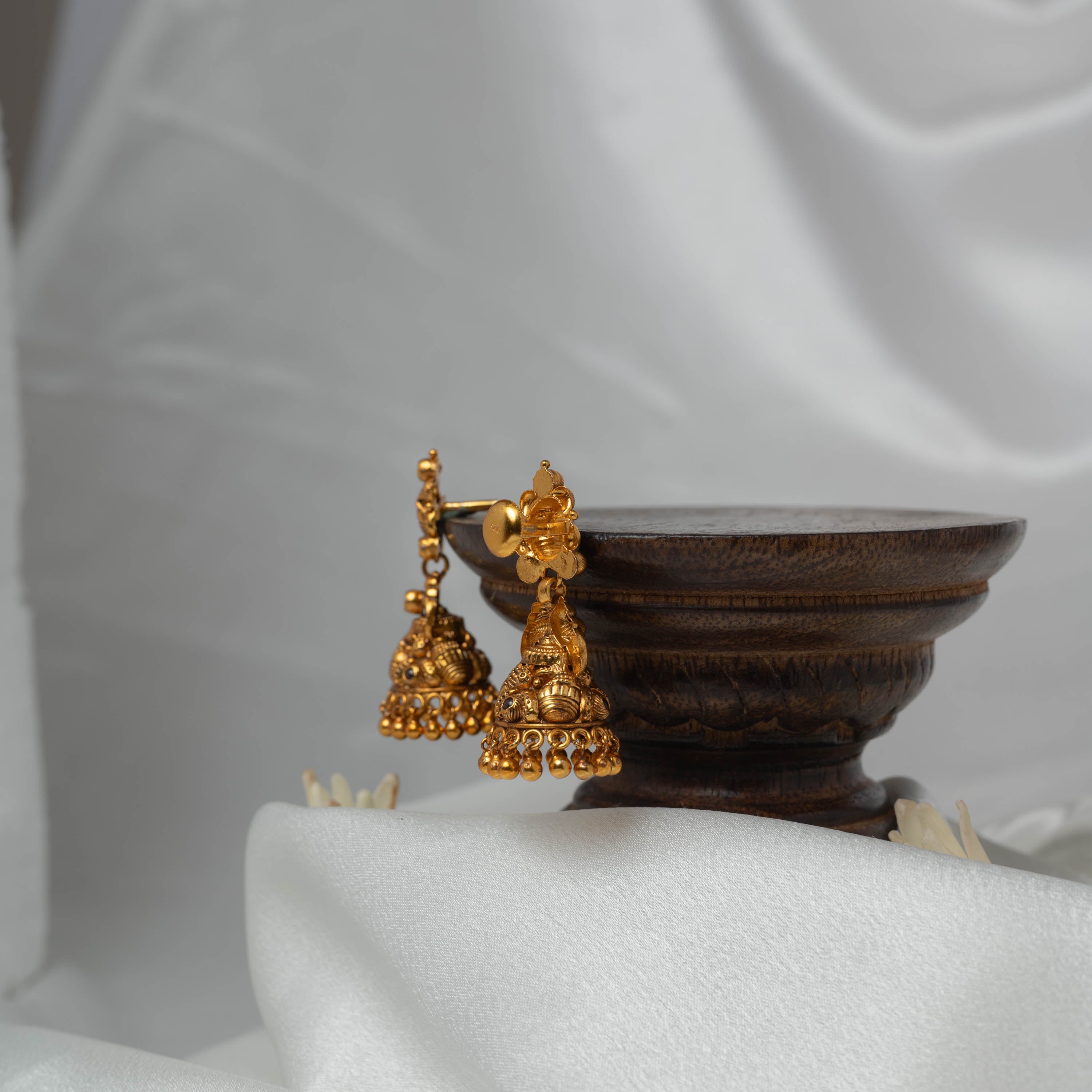 Angled view of the domed jhumka and the gold ball rim in antique gold 925 silver