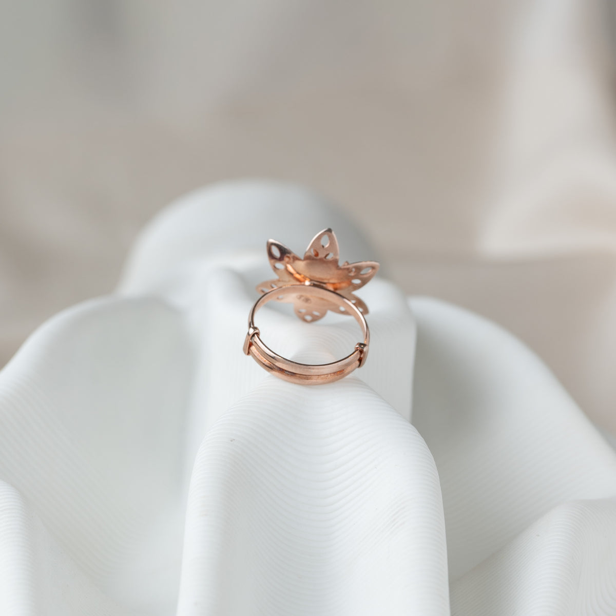 Underside of the flower ring showing the open sliding band in rose gold plated 925 silver