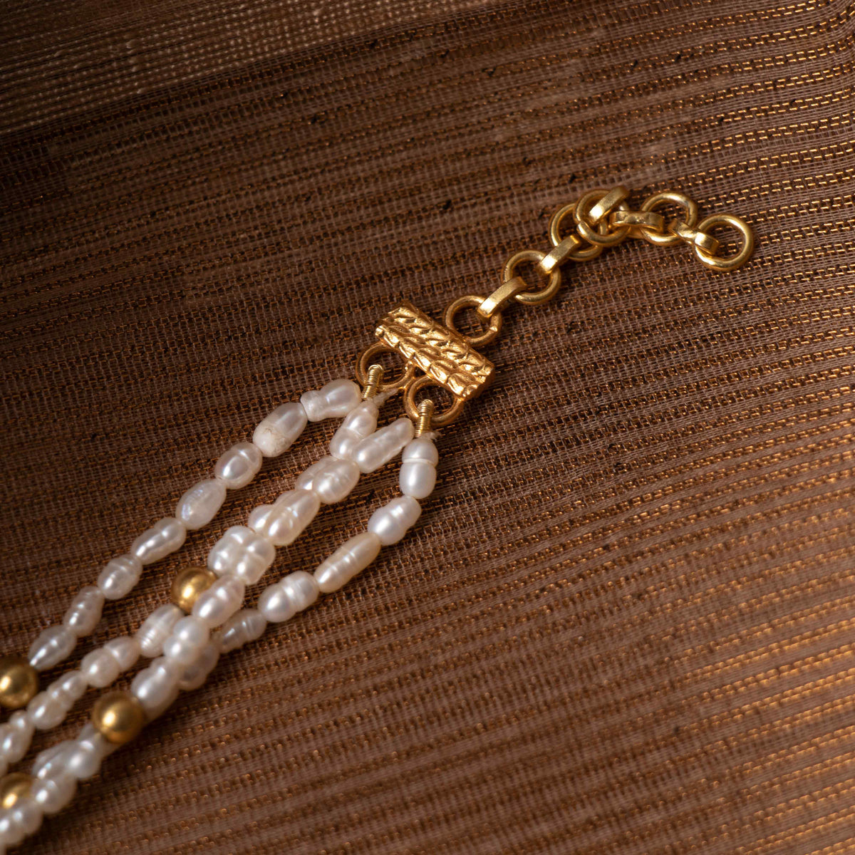 Green strawberry quartz beads ringing the kundan medallion on the pearl strands, close detail