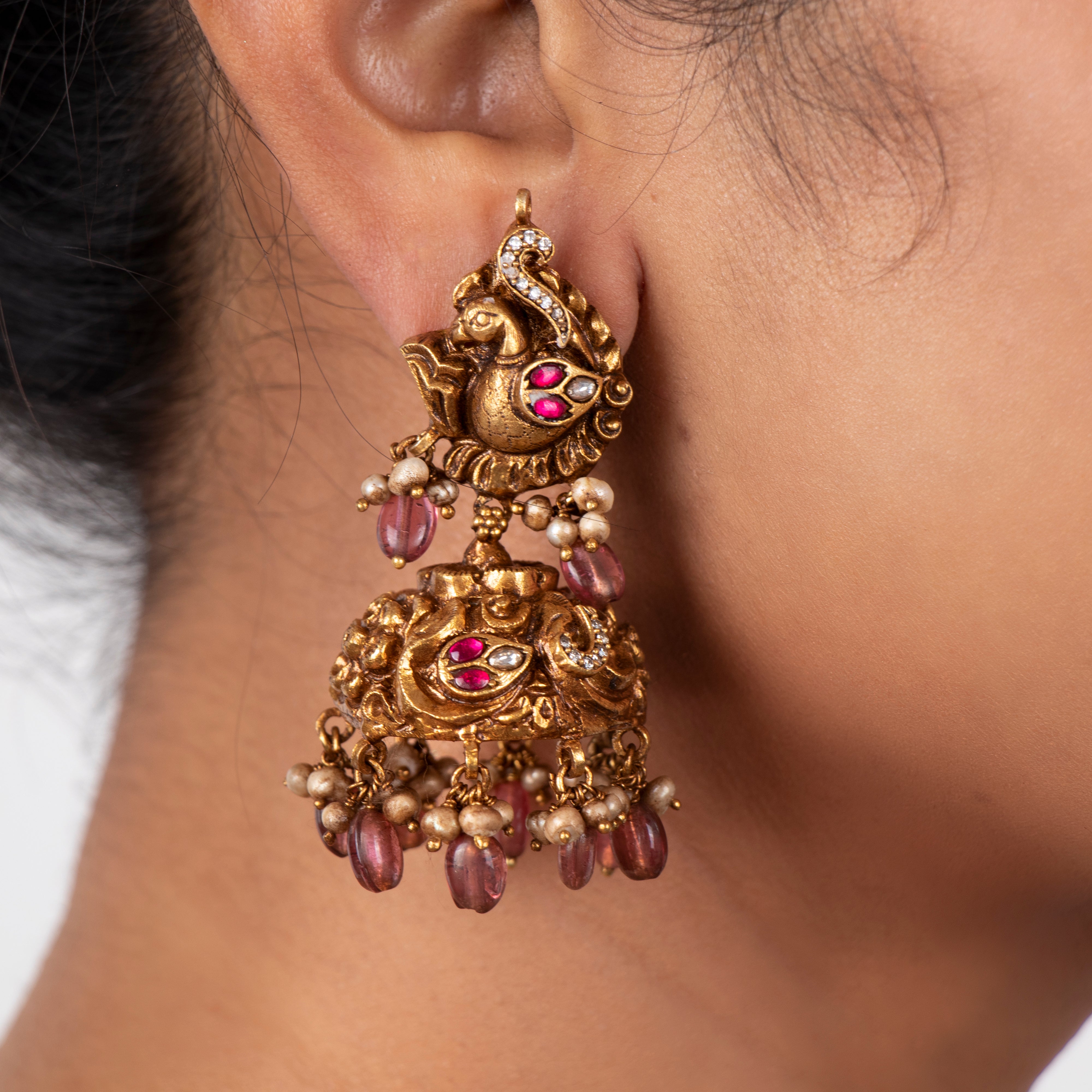 Model wearing Avyanna nakaas kundan jhumka earrings with pearl drops