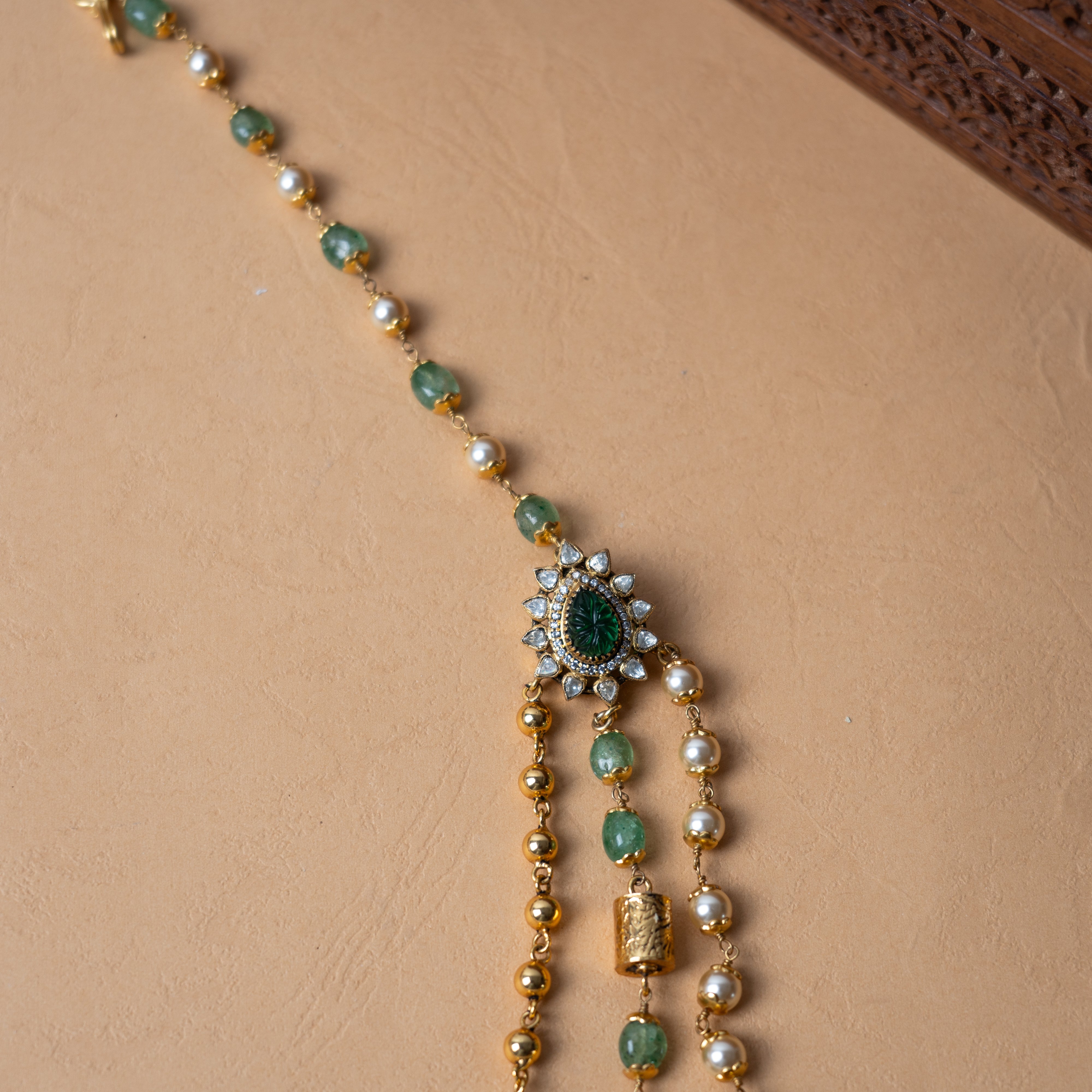 Close-up of Raya polki necklace with green gemstone beads and Swarovski pearl strands