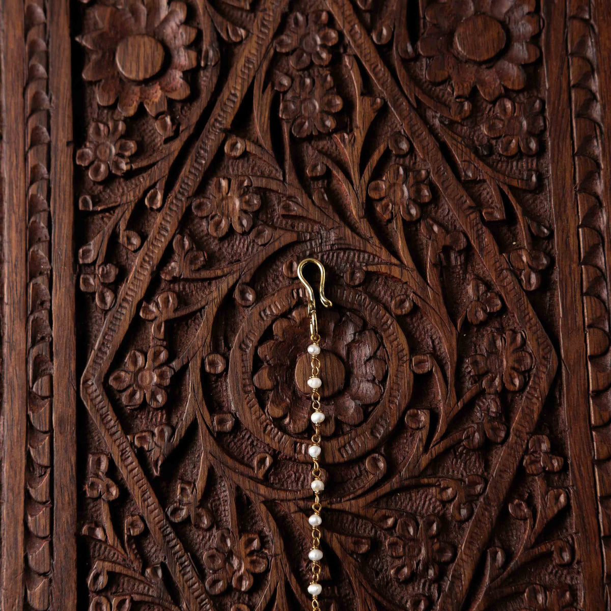 Pearl chain and fish hook behind the marquise polki maangtika in Victorian finish silver