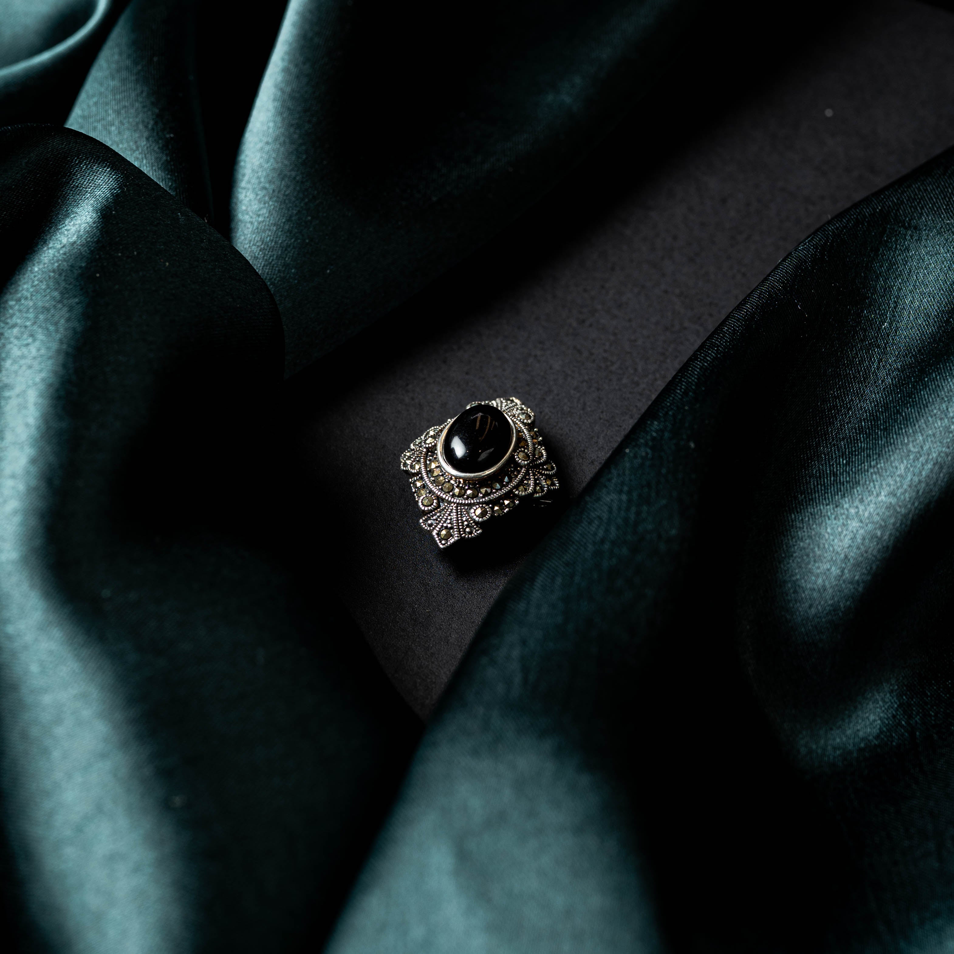 Tilted back view of the onyx brooch showing the pin and catch in oxidised 925 silver