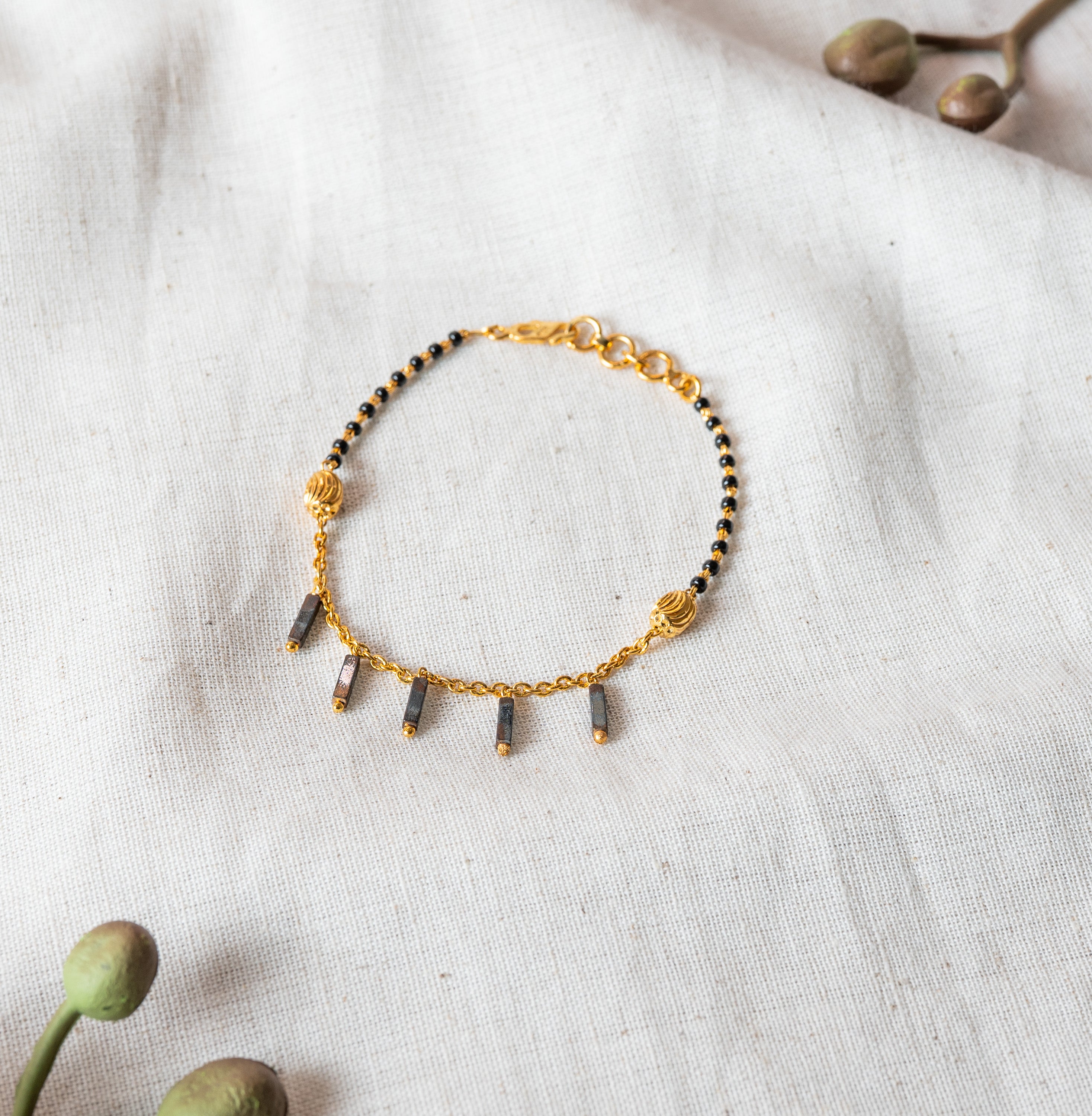 Close crop of the lobster clasp, extender rings and rectangular charm drops in gold plated 925 silver