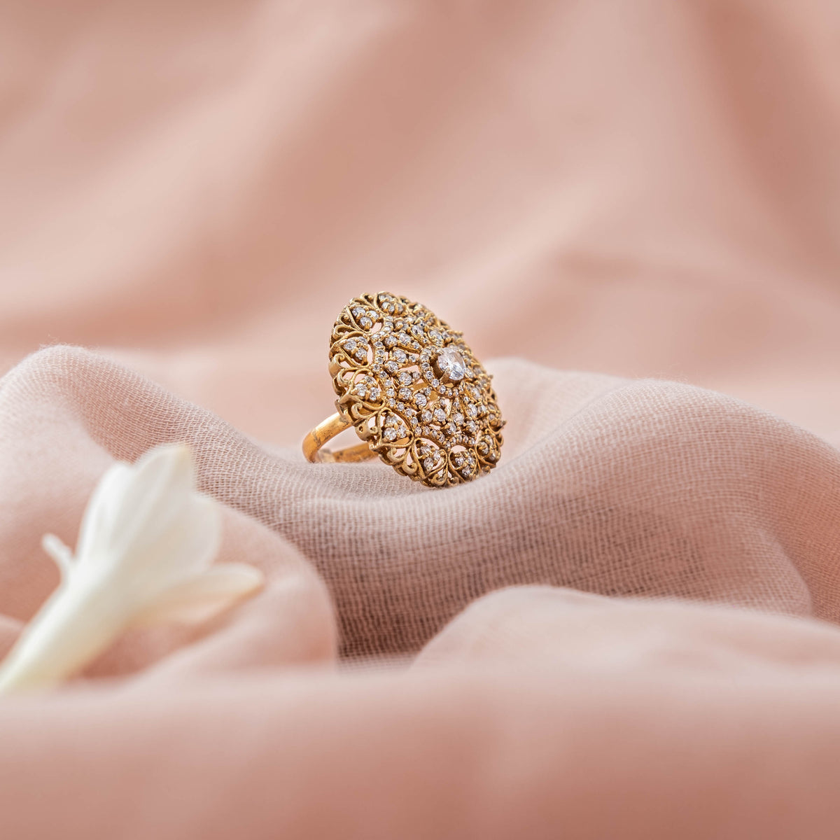 Angled view of the CZ scrollwork and polki accents across the tall oval face, gold plated 925 silver