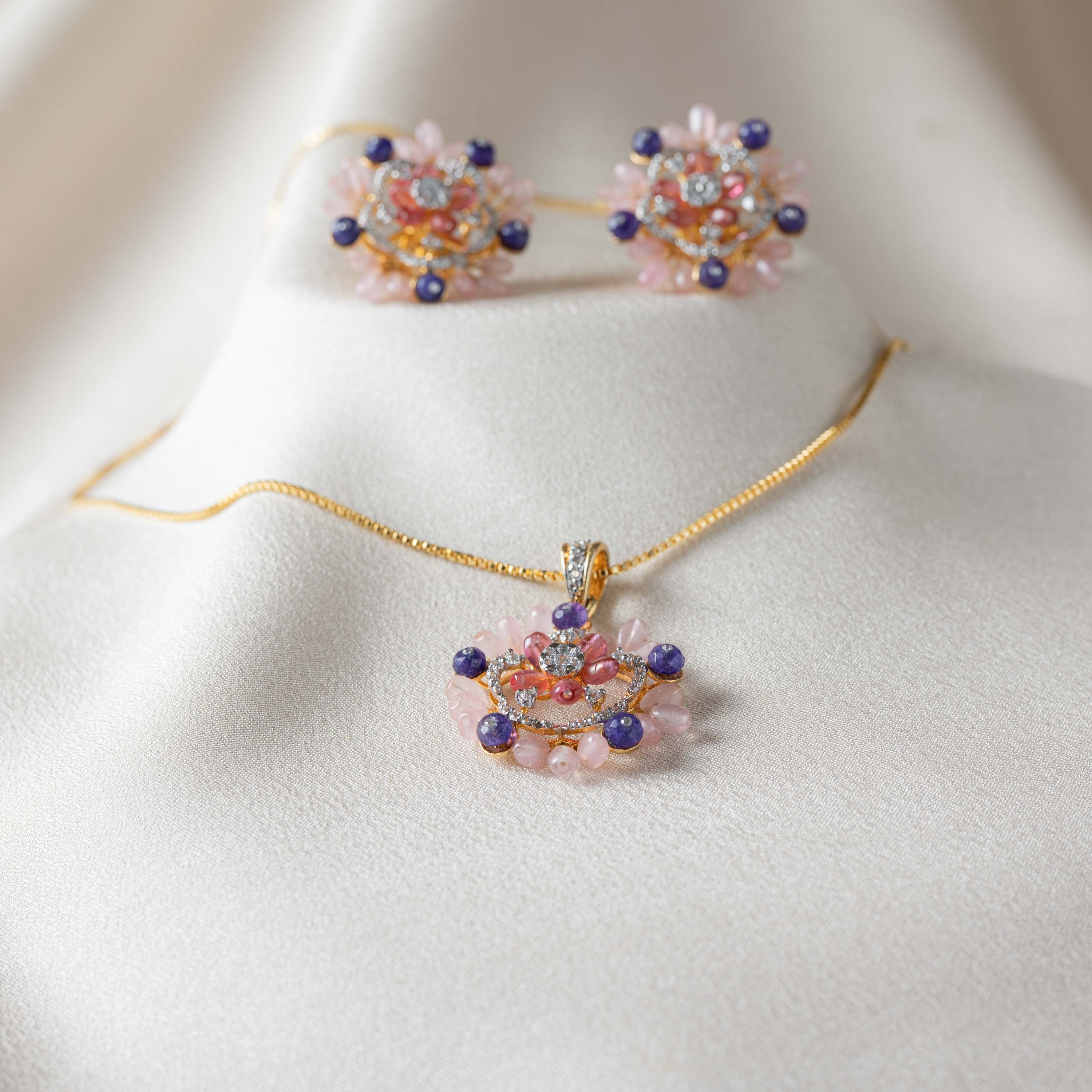 Angled view of the rose-pink teardrop petals around the CZ centre of the gold plated pendant