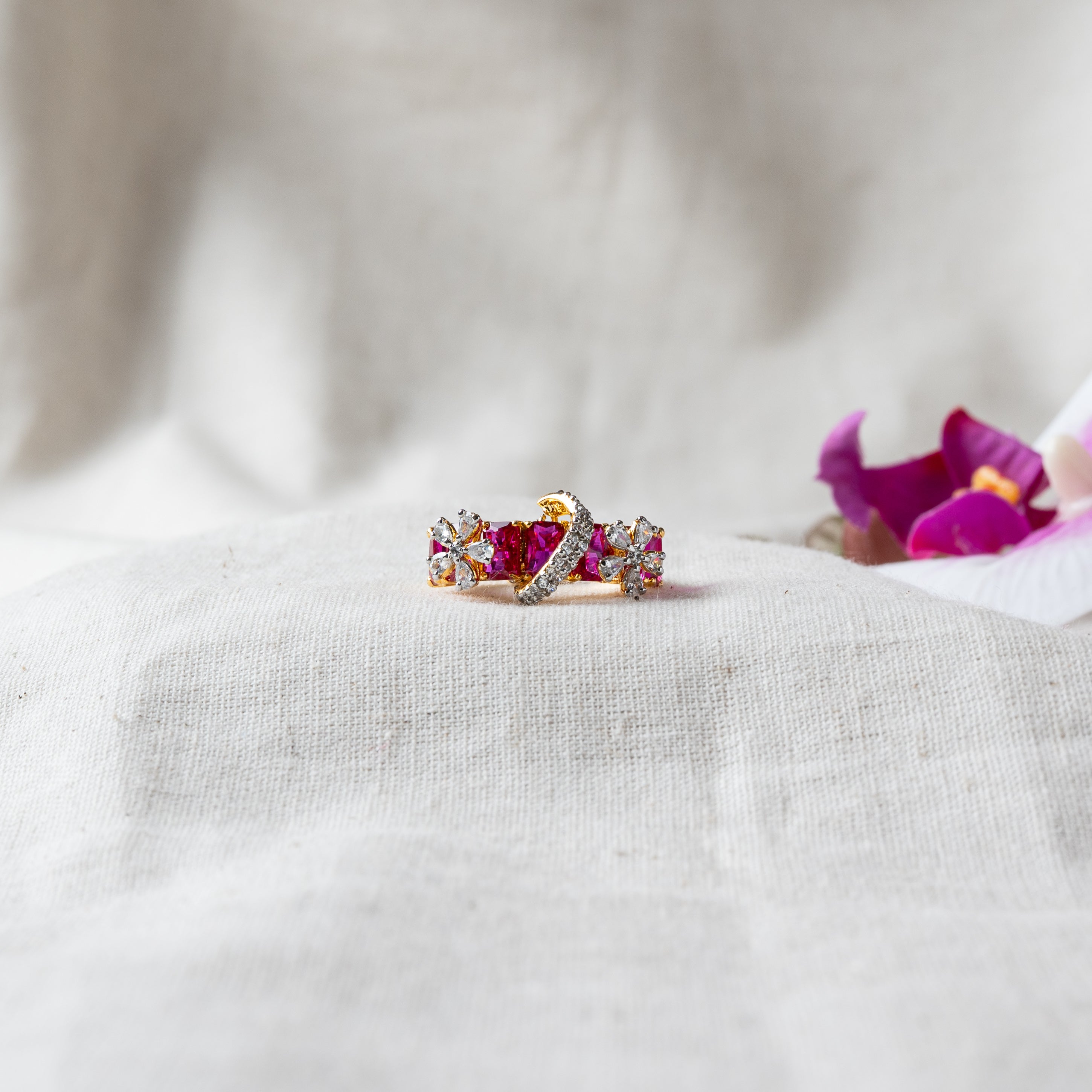 Ring with a wave of marquise ruby and CZ stones in gold plated 925 silver, set on cream cloth