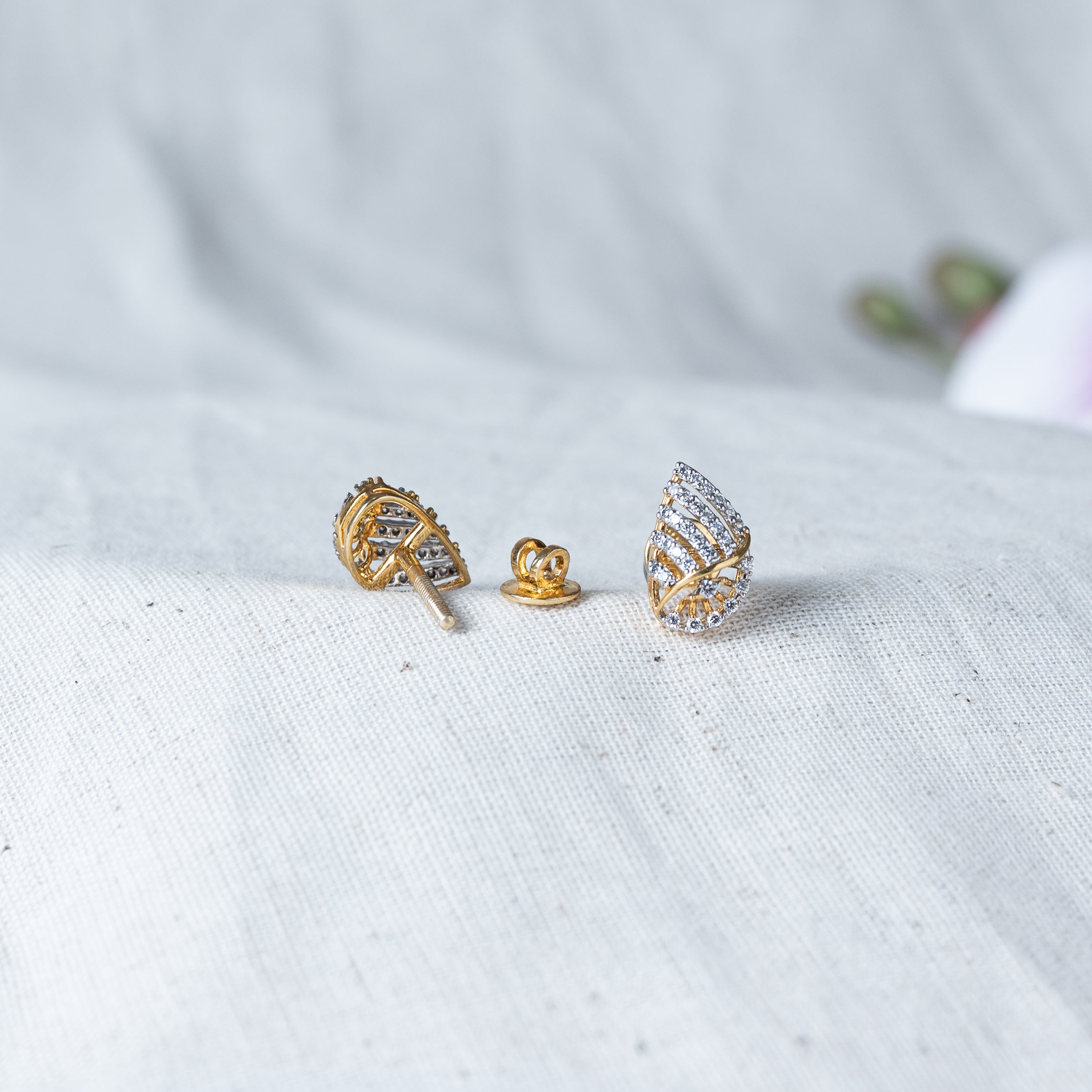 Pair of CZ paved twist studs laid on cloth, rhodium finish 925 silver