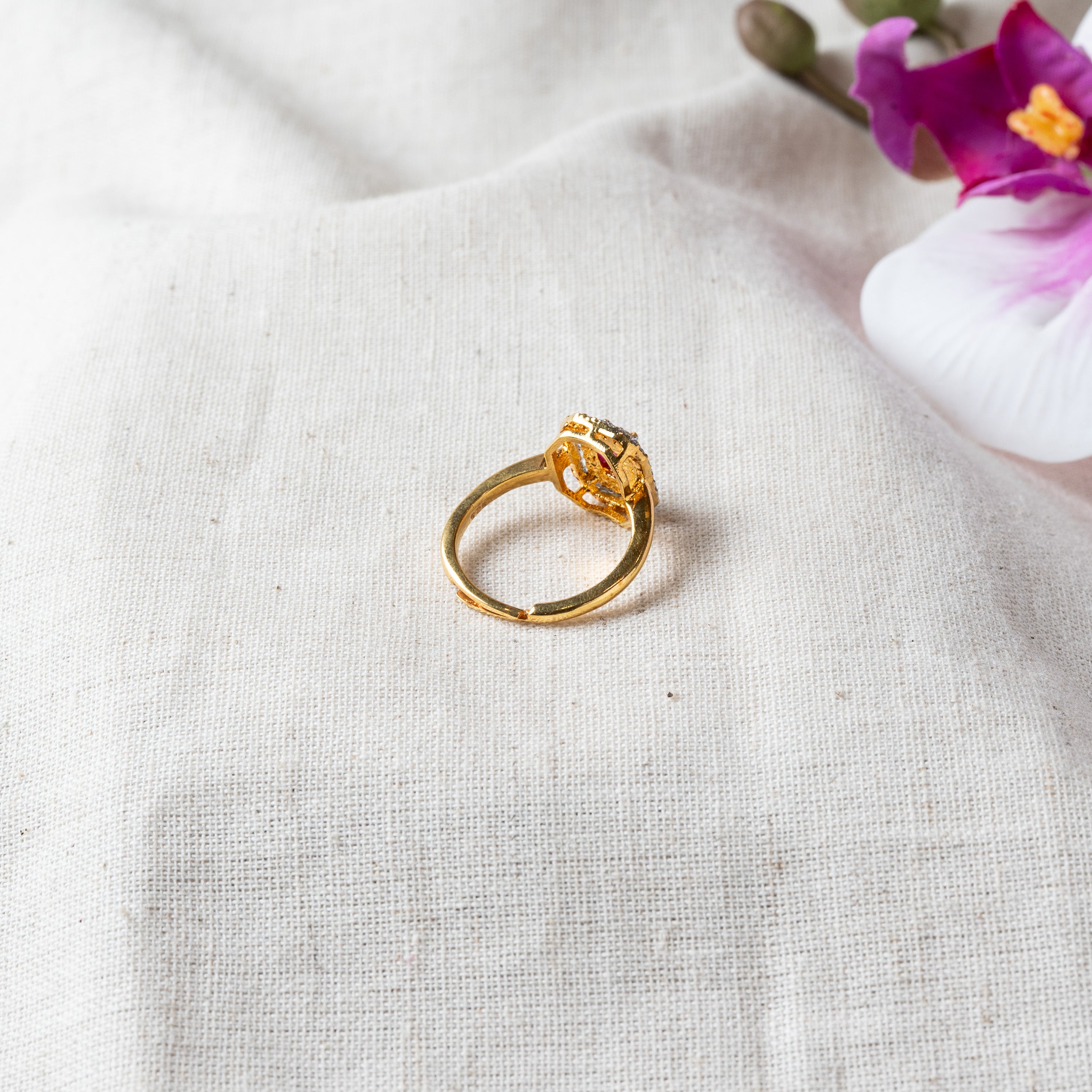 Side view of the plain gold plated band and open adjustable shank under the ruby setting