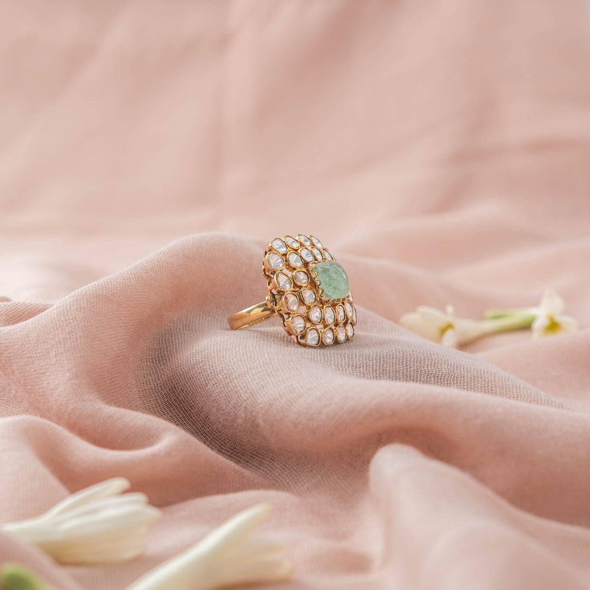 Carved green centre stone between two rows of uncut polki, angled view, gold plated 925 silver