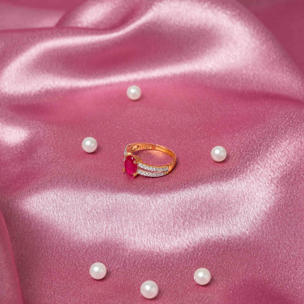 Detail of the split CZ pave band rising to a deep red oval centre stone