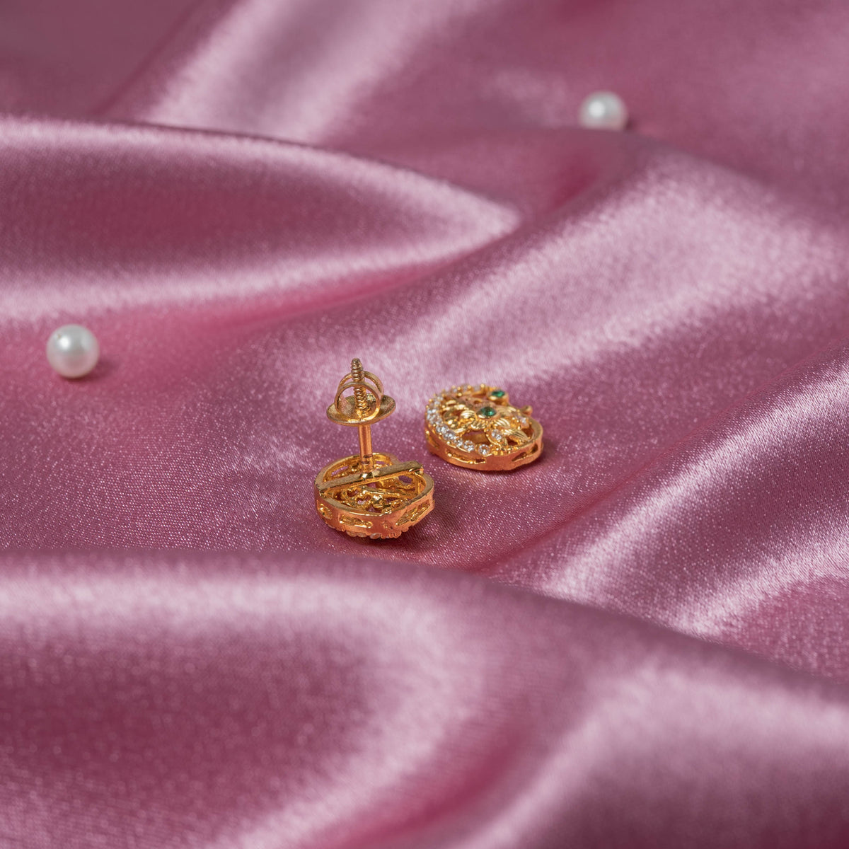 Detail of the mango outline in white CZ with a green centre on gold plated stud earrings