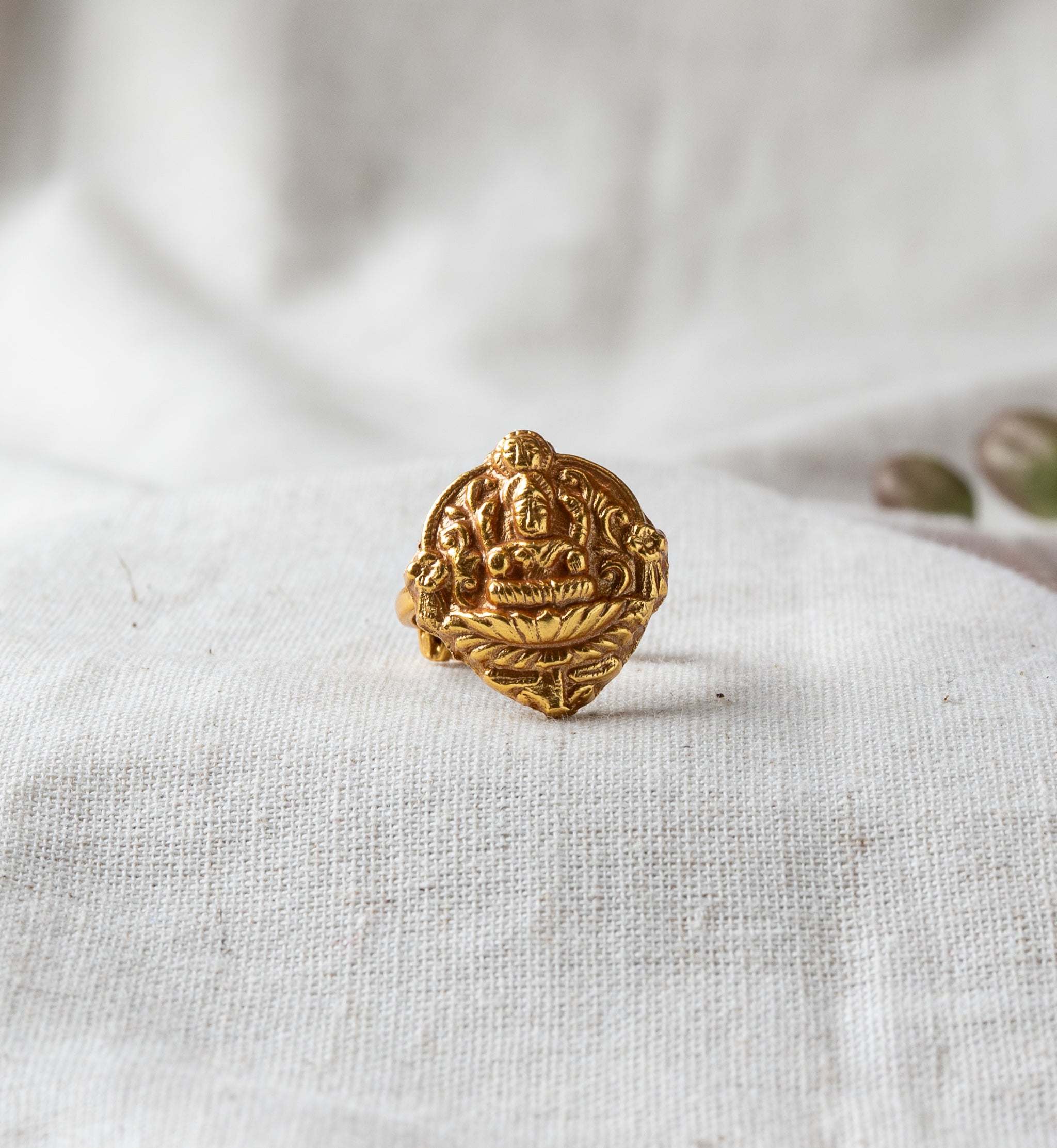 Lakshmi coin ring seen at an angle, engraved motif and adjustable band in antique gold plated 925 silver