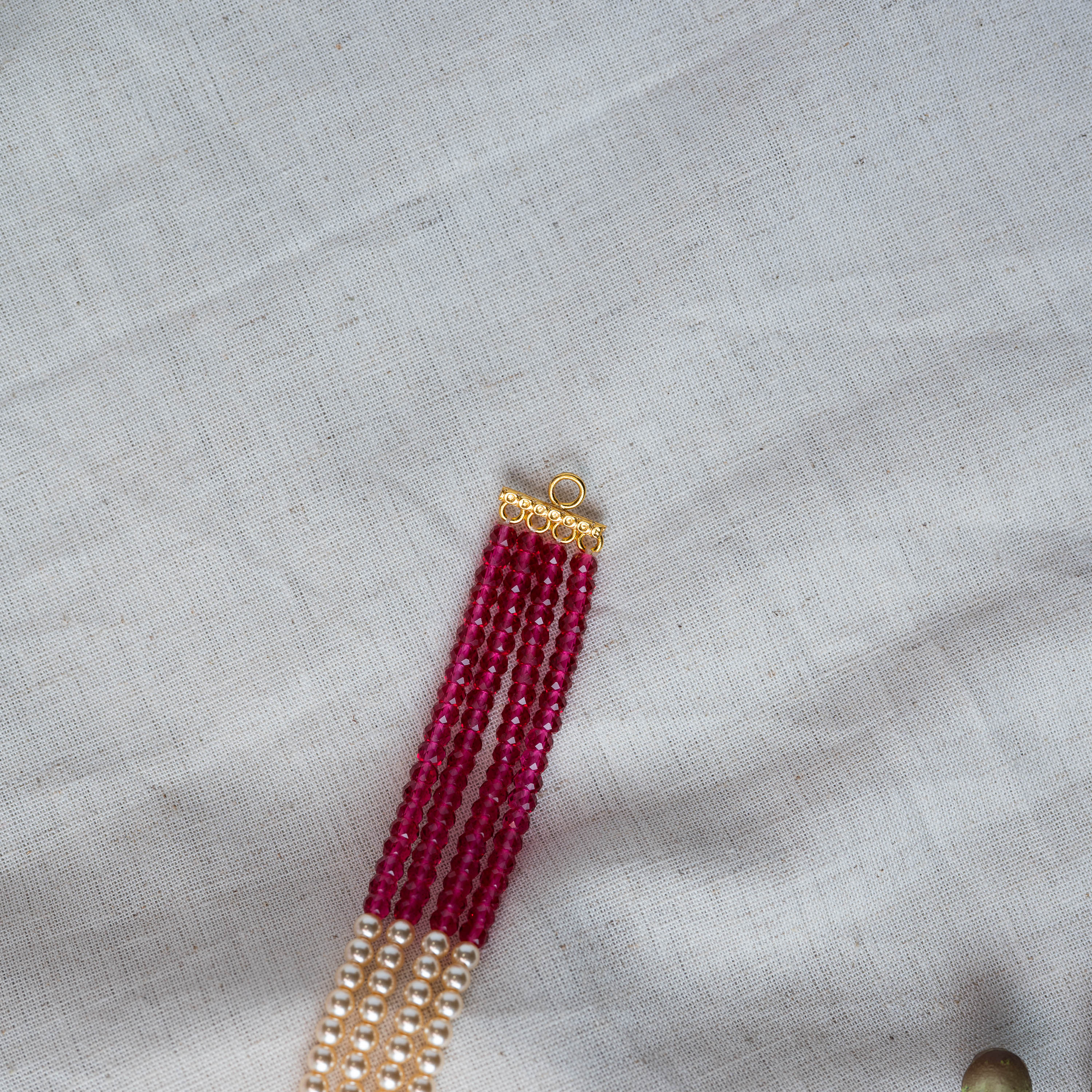 Multi strand choker of pearl and ruby beads with a CZ framed ruby centre in gold plated 925 silver