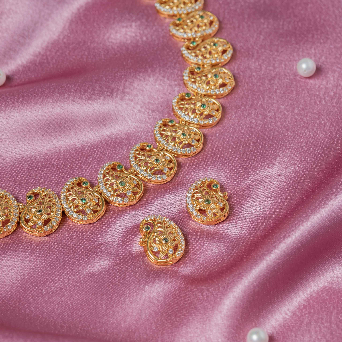 Close crop of a green stone centred in one ambi with the dori tie behind the necklace