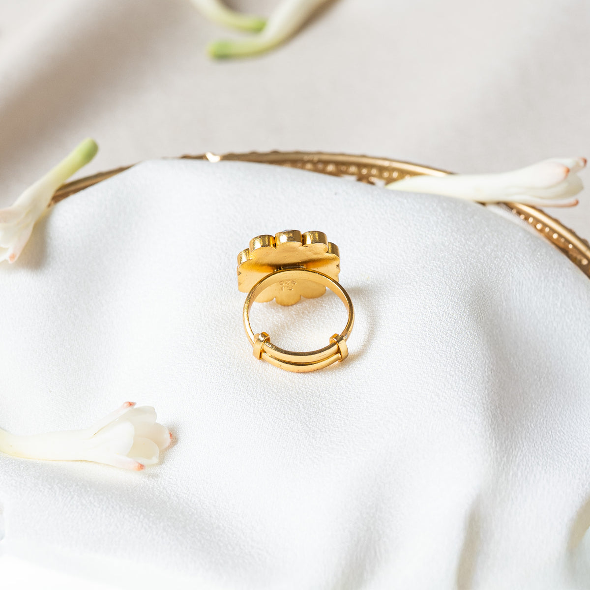 Underside of the kundan ring showing the sliding band tail passing through two gold loops