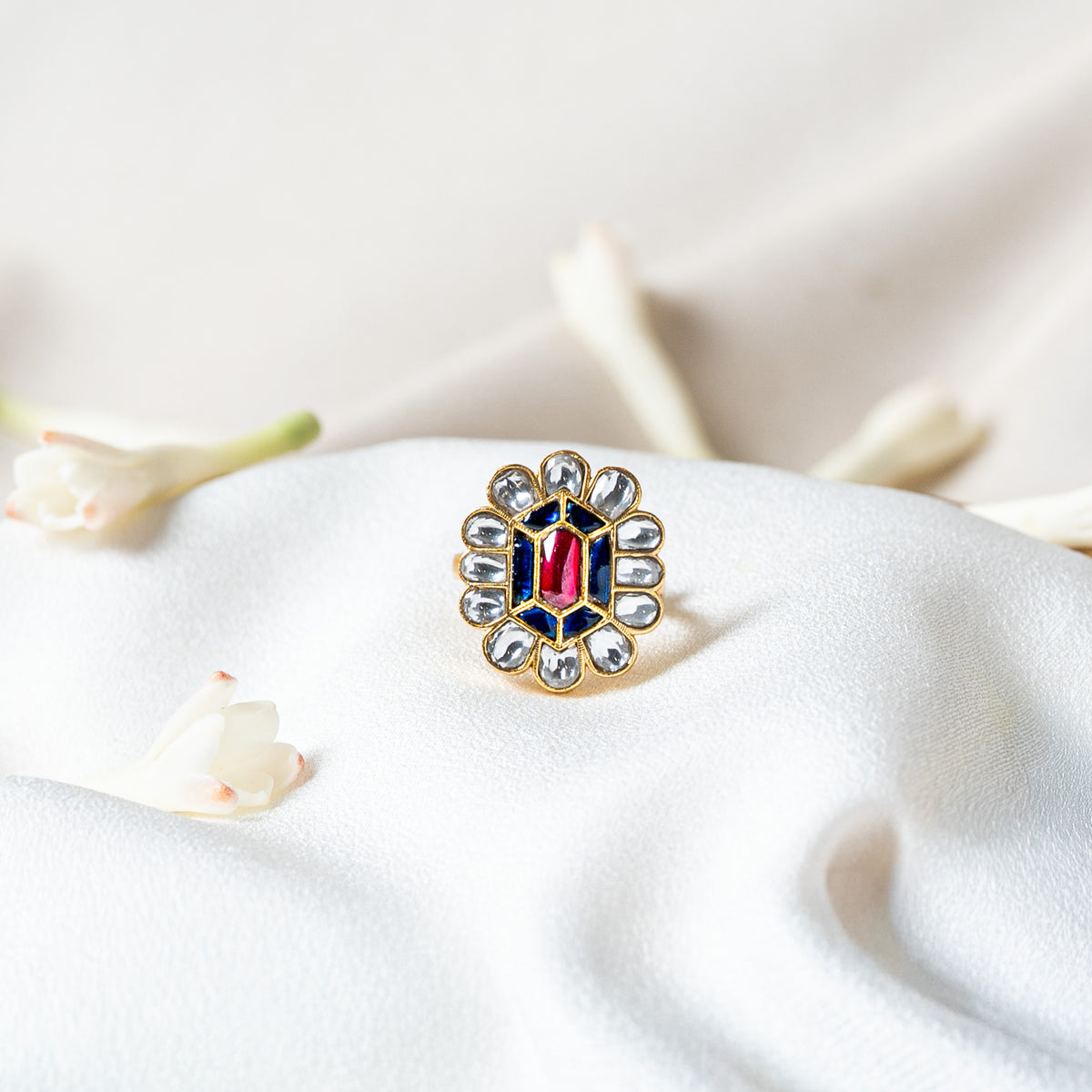 Close view of the white kundan petal halo ringing the blue and pink red flower head