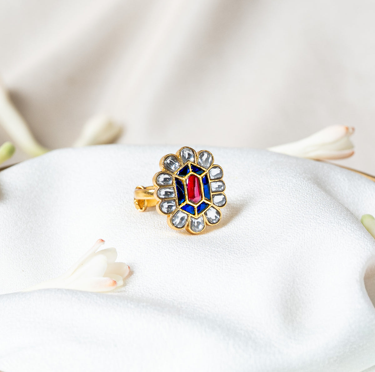 Kundan floral ring with a pink red hexagonal centre, blue kundan field and white petal halo