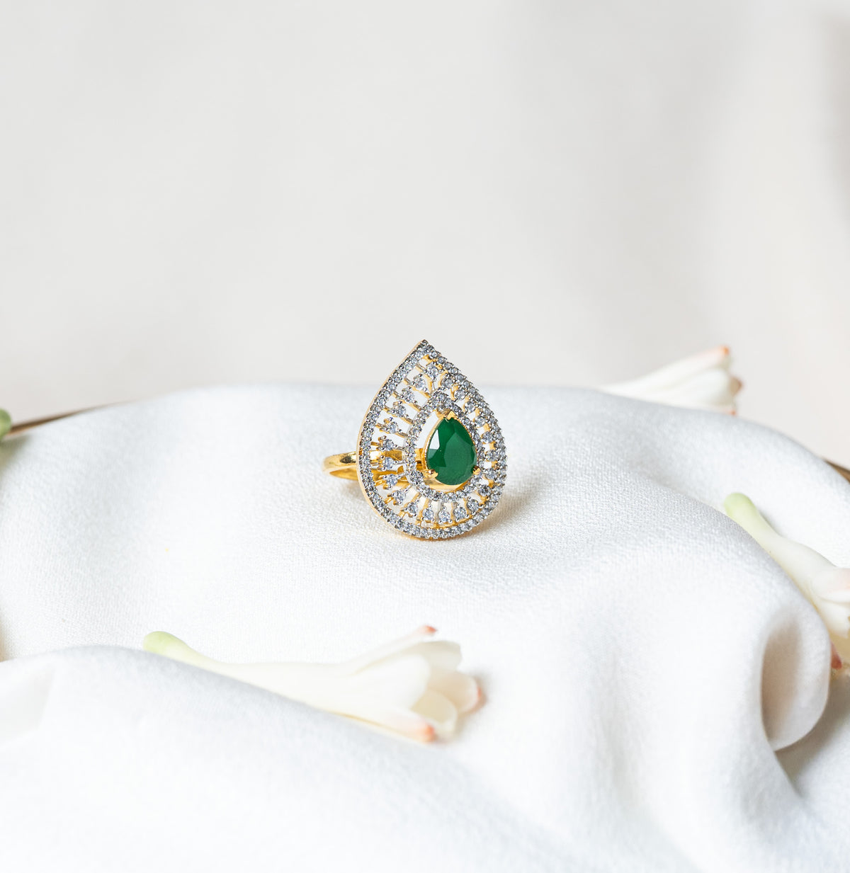 Front view of the CZ teardrop ring with gold spokes radiating from the green centre stone
