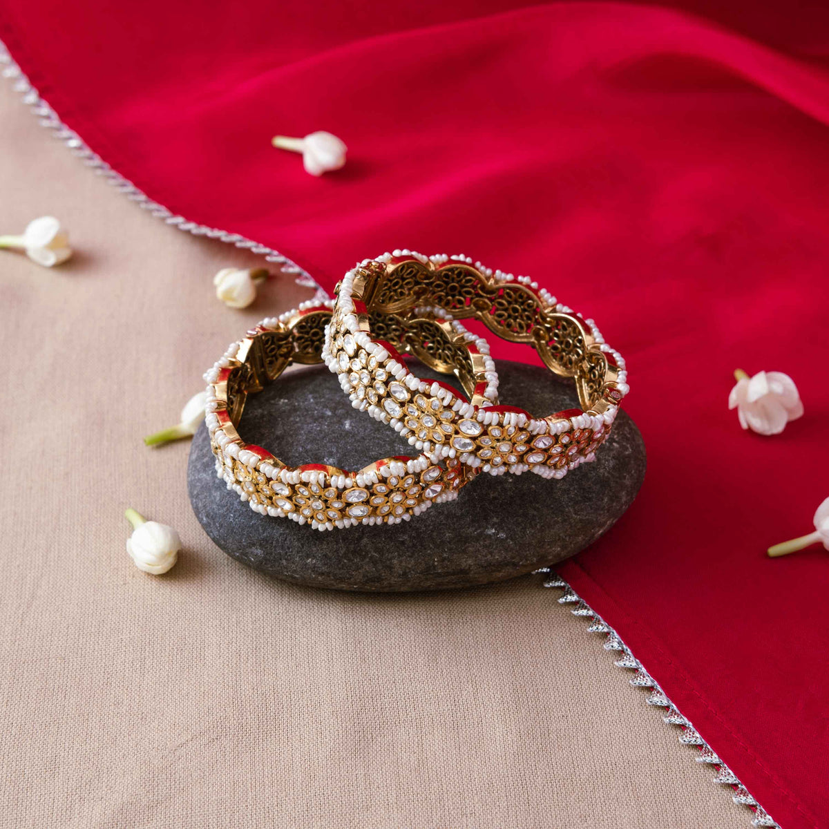 Rows of rice pearls set around white polki florets on a gold plated 925 silver bangle