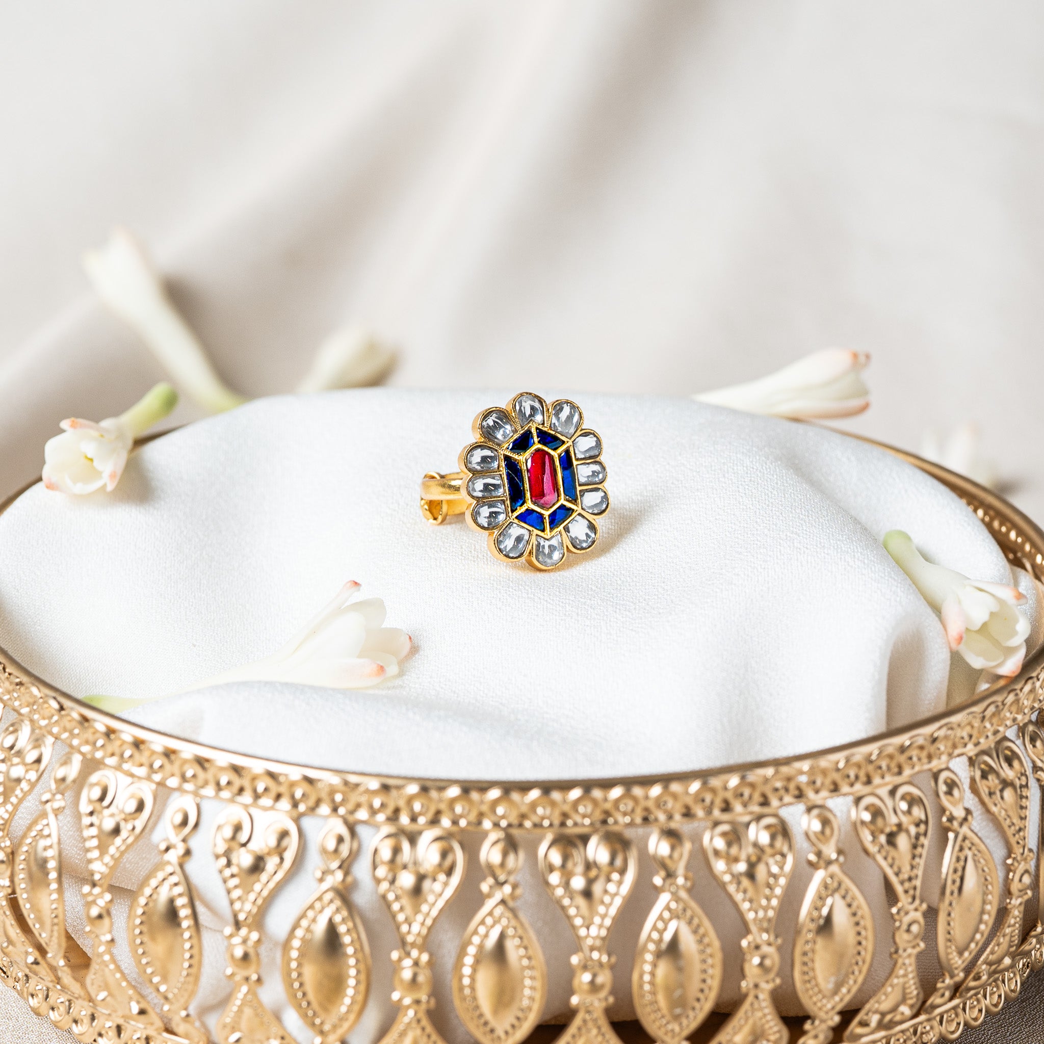 Kundan floral ring with a pink red hexagonal centre, blue kundan field and white petal halo