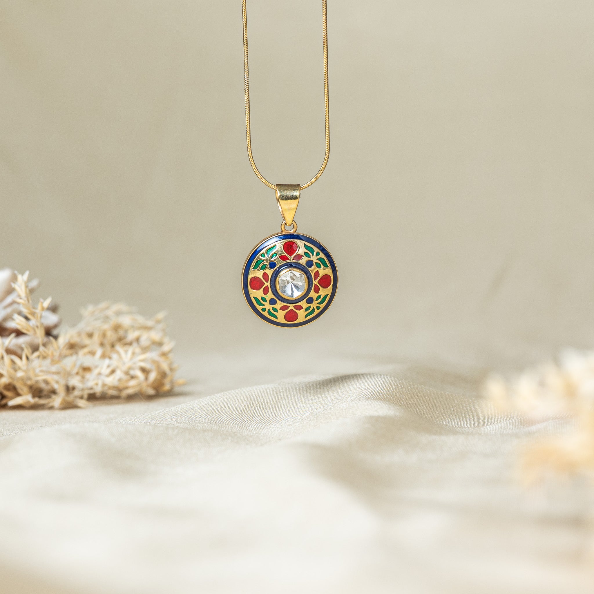 Polki and meenakari pendant with an uncut centre stone on cobalt blue fired enamel, shown on a snake chain