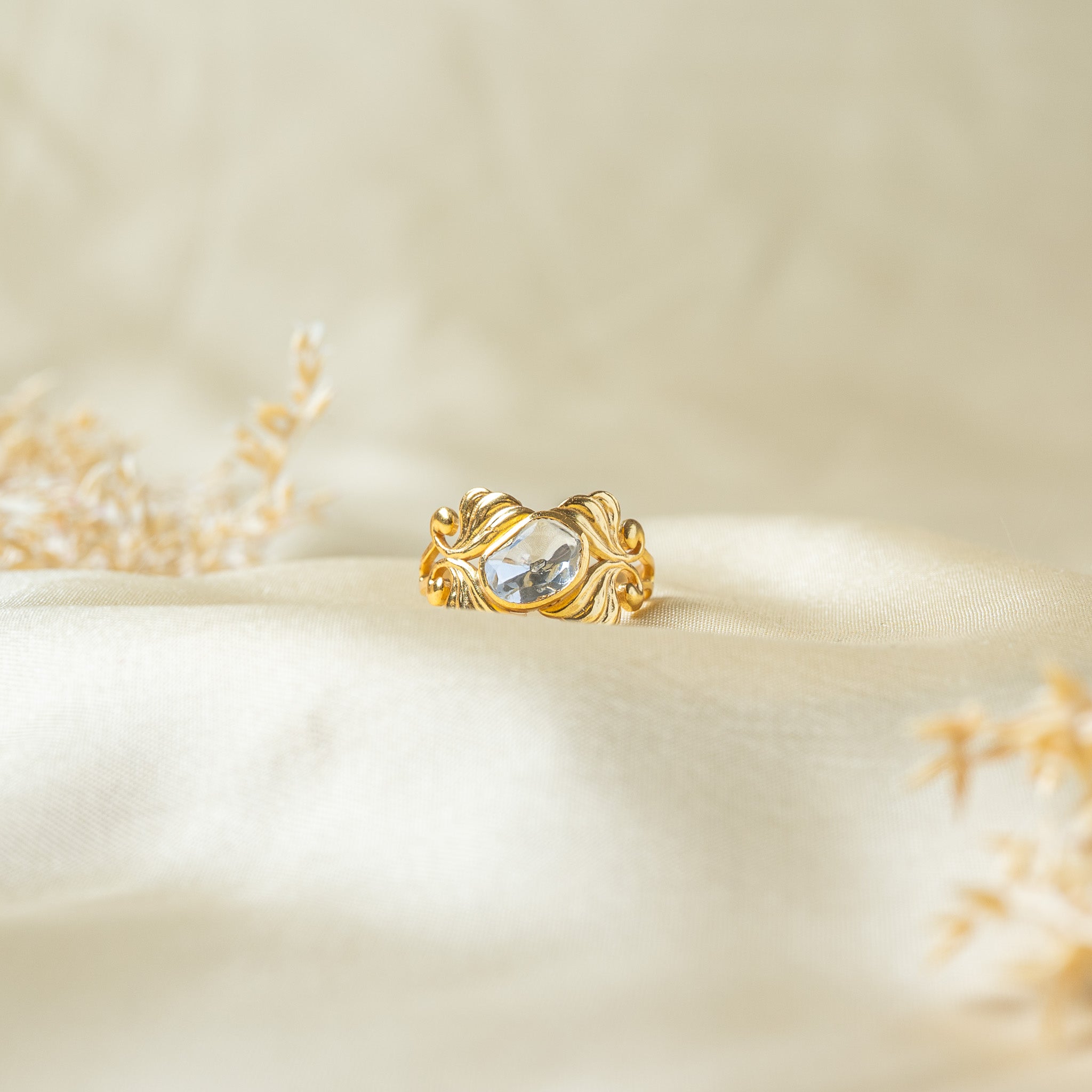 Uncut polki ring set across the band between ribbed leaf plumes with spiral gold buds