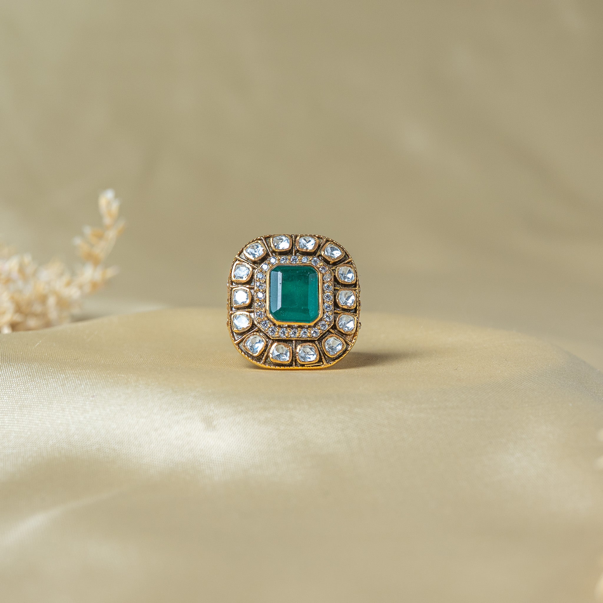Victorian cocktail ring with a green step cut centre, CZ halo and fourteen flat uncut stones