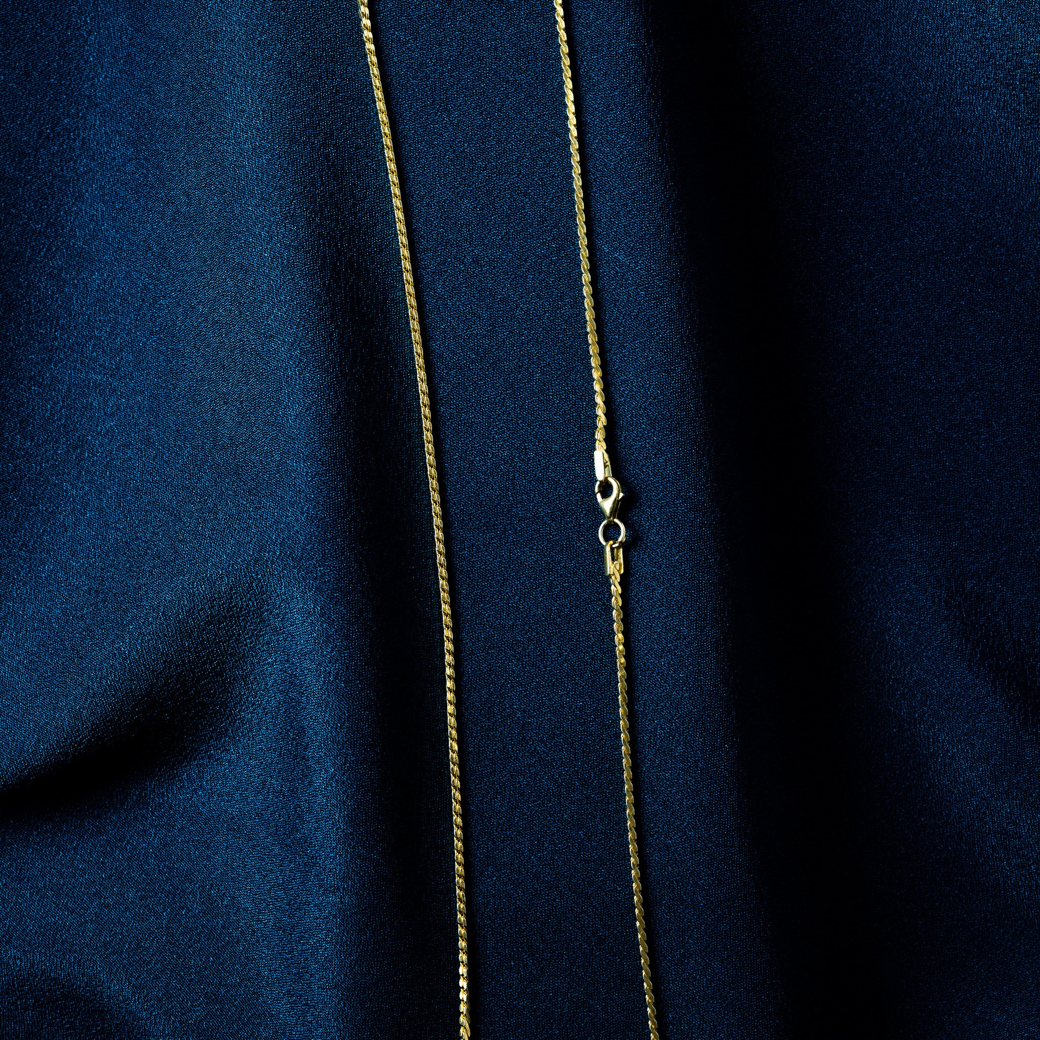 Lobster clasp on a gold rope chain, close crop of the hinged trigger and end cap