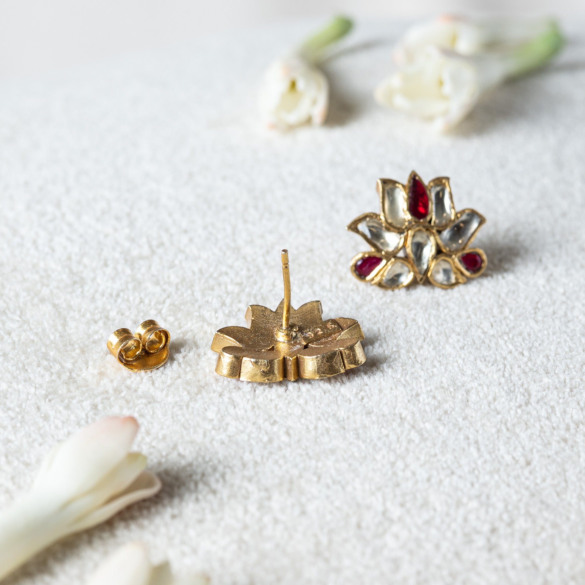 Red and white kundan lotus stud seen from behind with its smooth post and gold push back