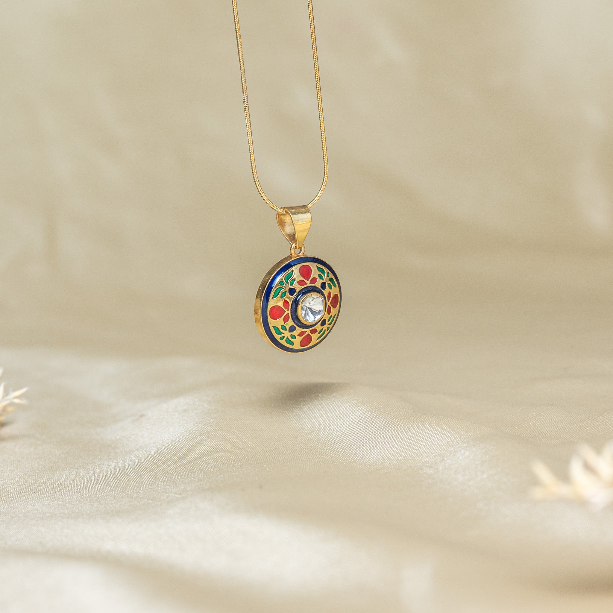 Close view of the fired blue meenakari disc and its uncut polki centre in gold plated silver