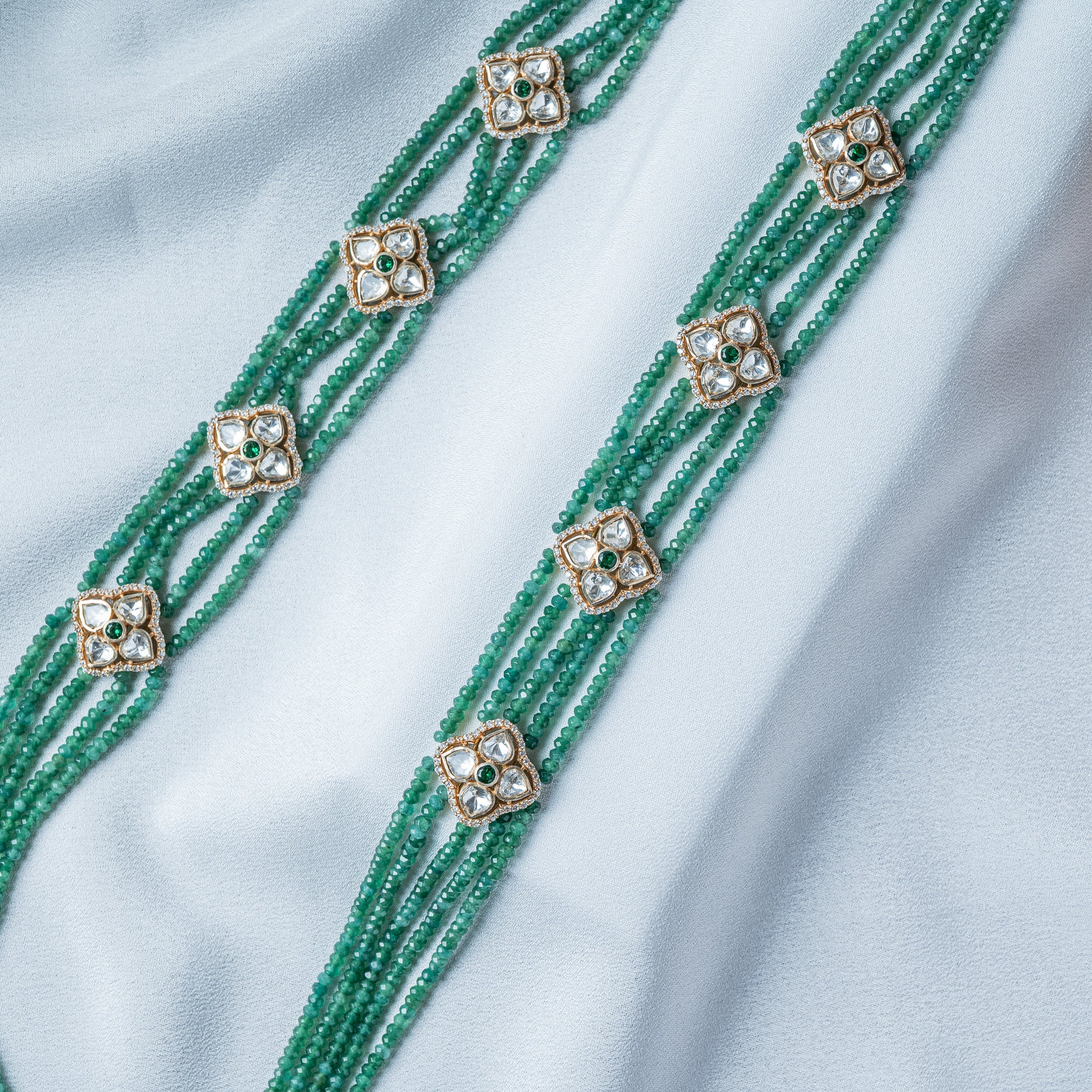 Spacer close up, four flat uncut white stones set as petals around a small green centre