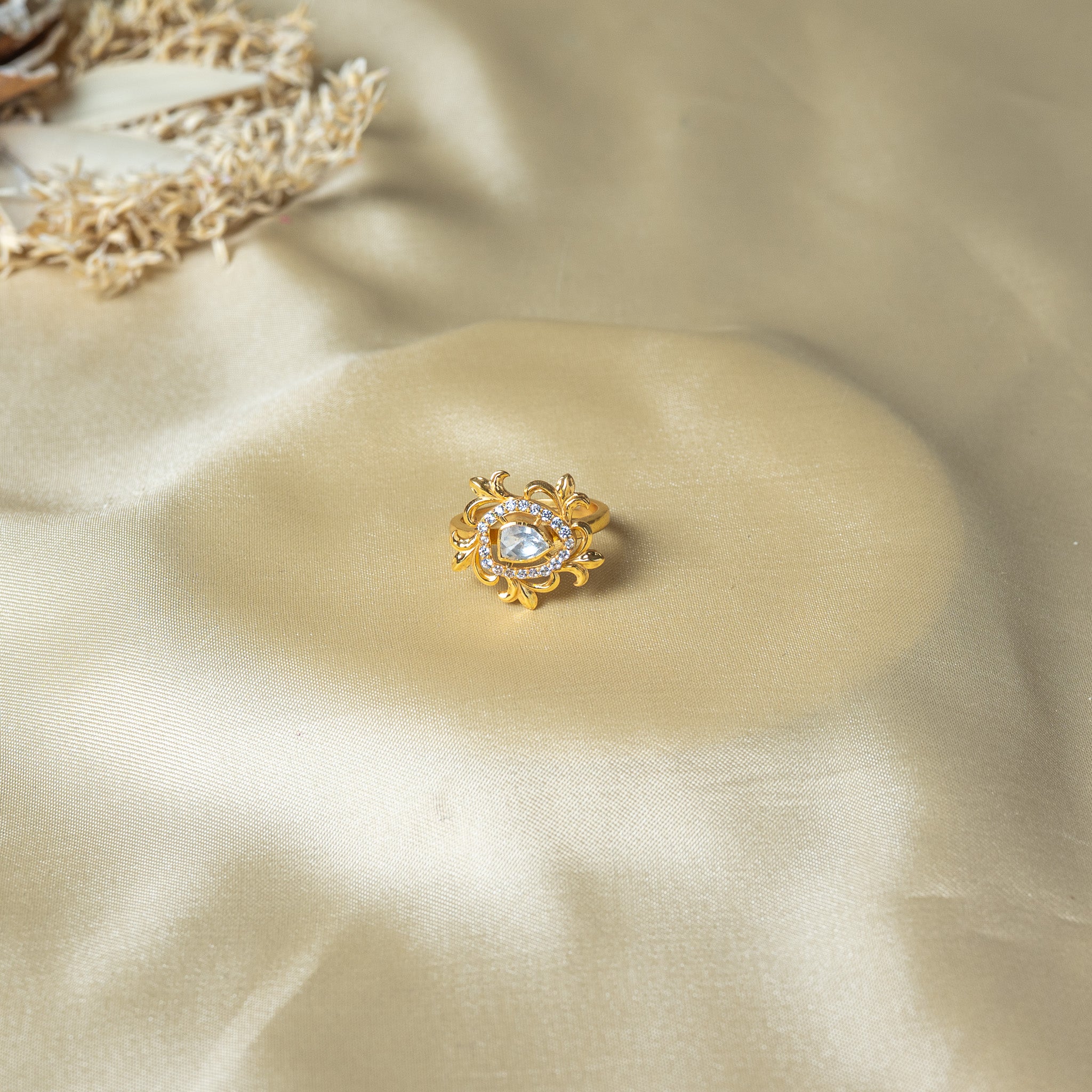 Close view of the flat topped pear polki centre stone ringed by bright faceted CZ