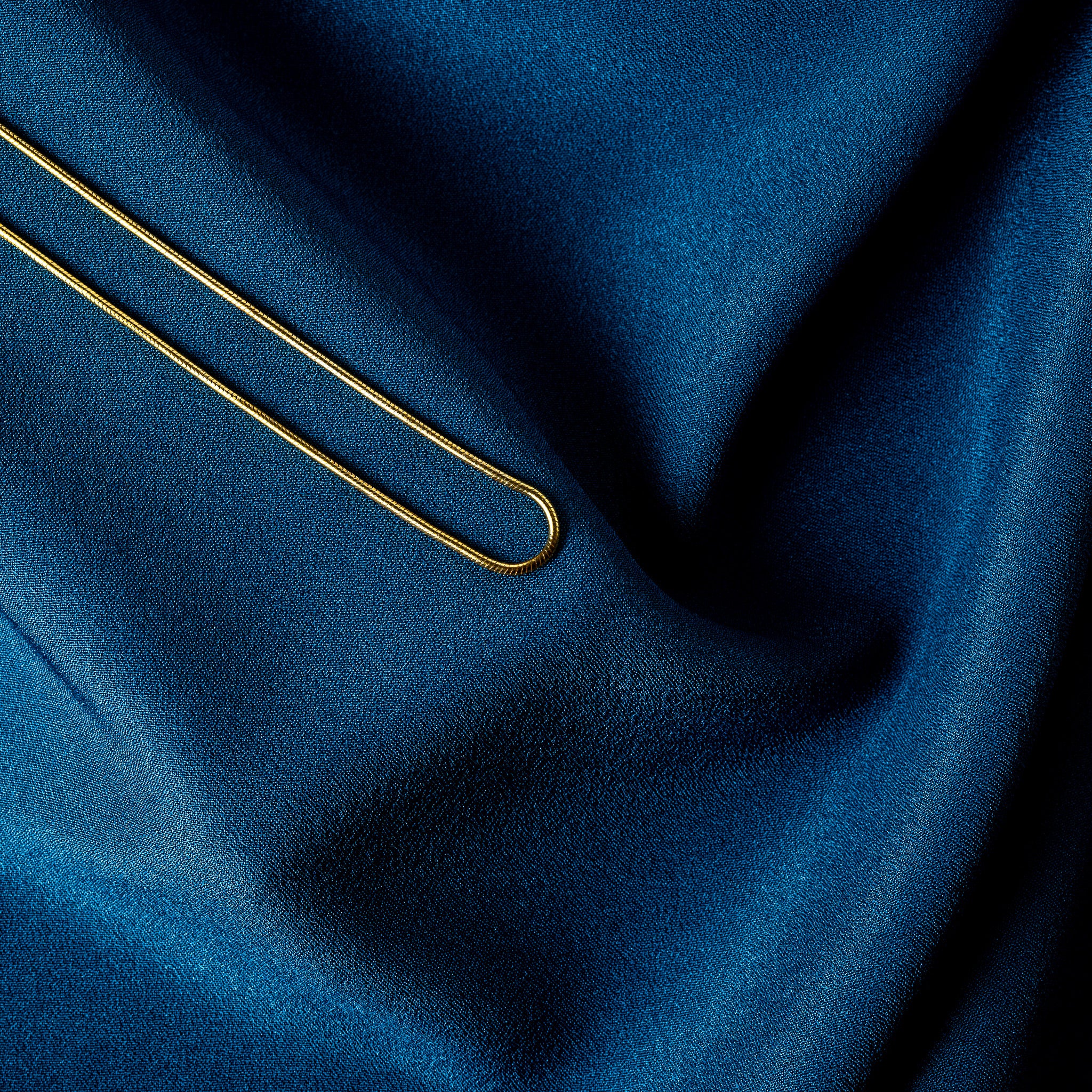 Fine transverse banding along a gold snake chain, macro of the 1.2 mm tube