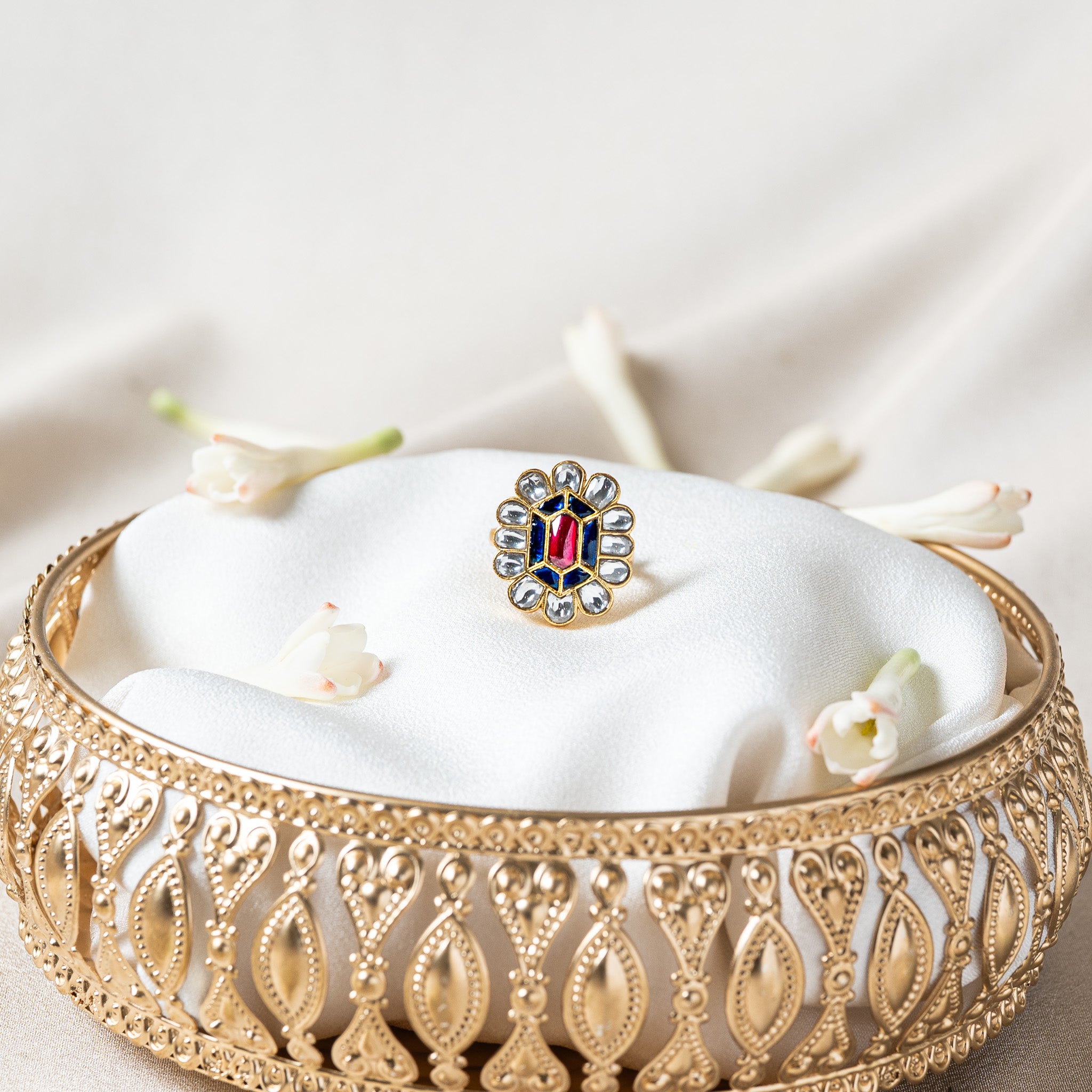 Close view of the white kundan petal halo ringing the blue and pink red flower head