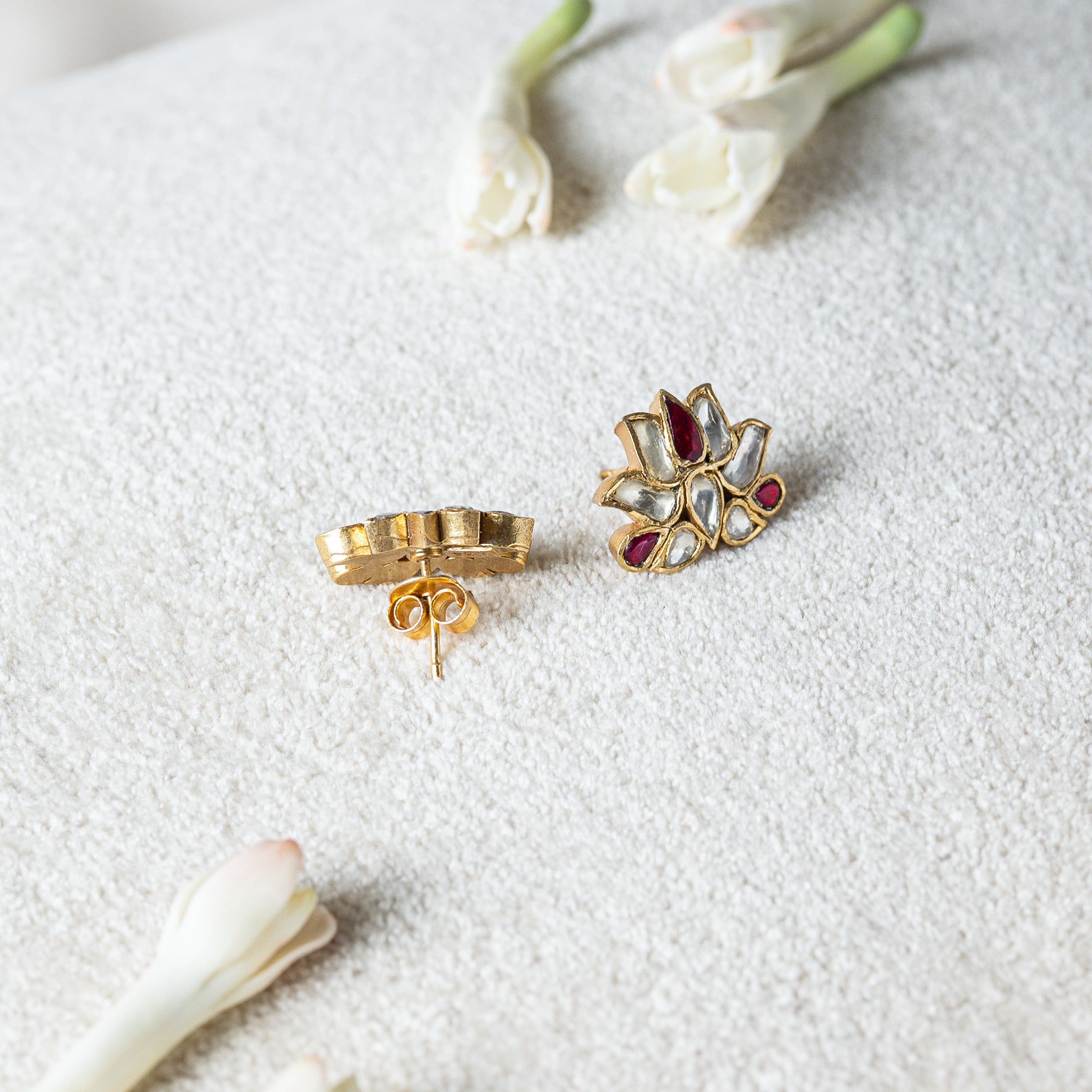 Pair of red accented lotus studs, backs shown with both push backs taken off