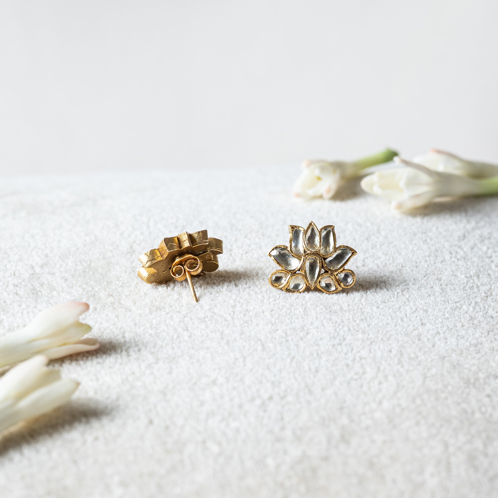 Pair of white lotus studs seen from behind with the flat back plate and both push backs off